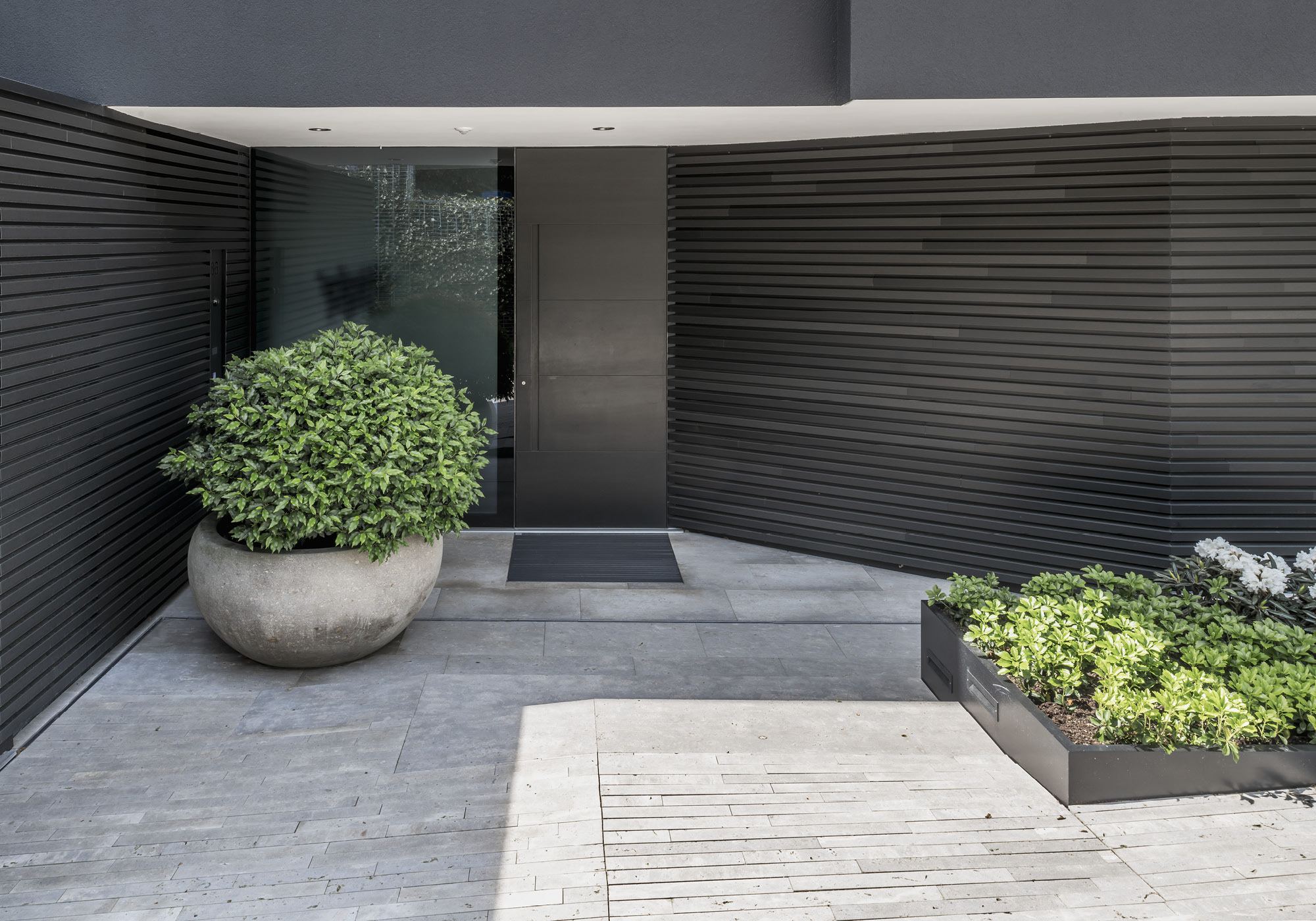 Entrance area with timber slats and planters – Single-family house in Meilen