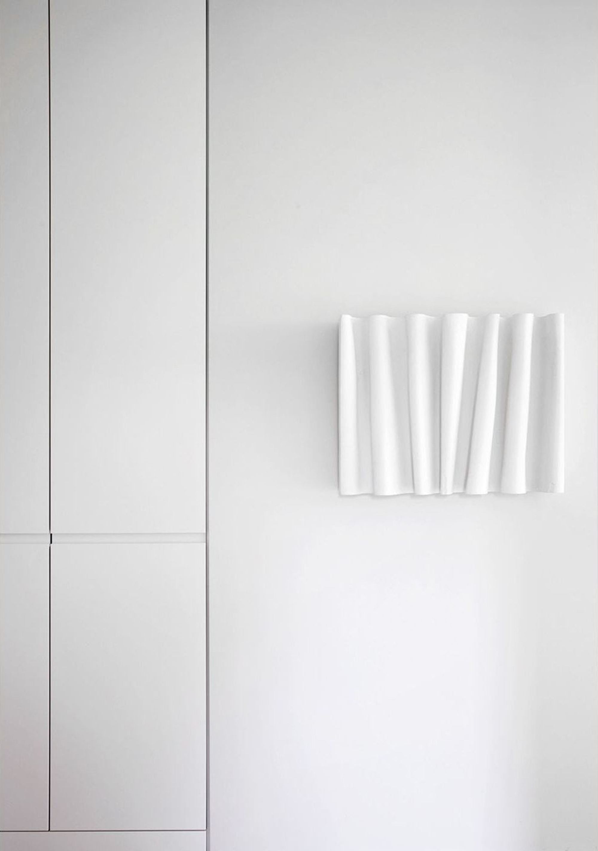 White wall with sculptural wall piece – Apartment building in Uitikon