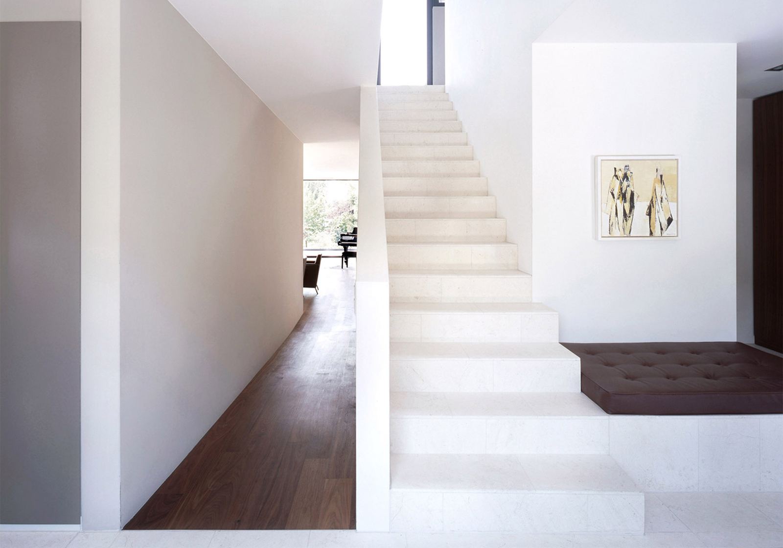 White staircase with bench in the hallway