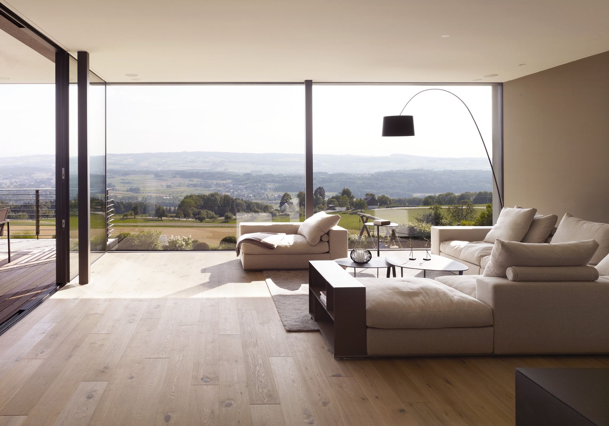 Living room with arc lamp and panoramic view – Single-family house in Oberwil-Lieli