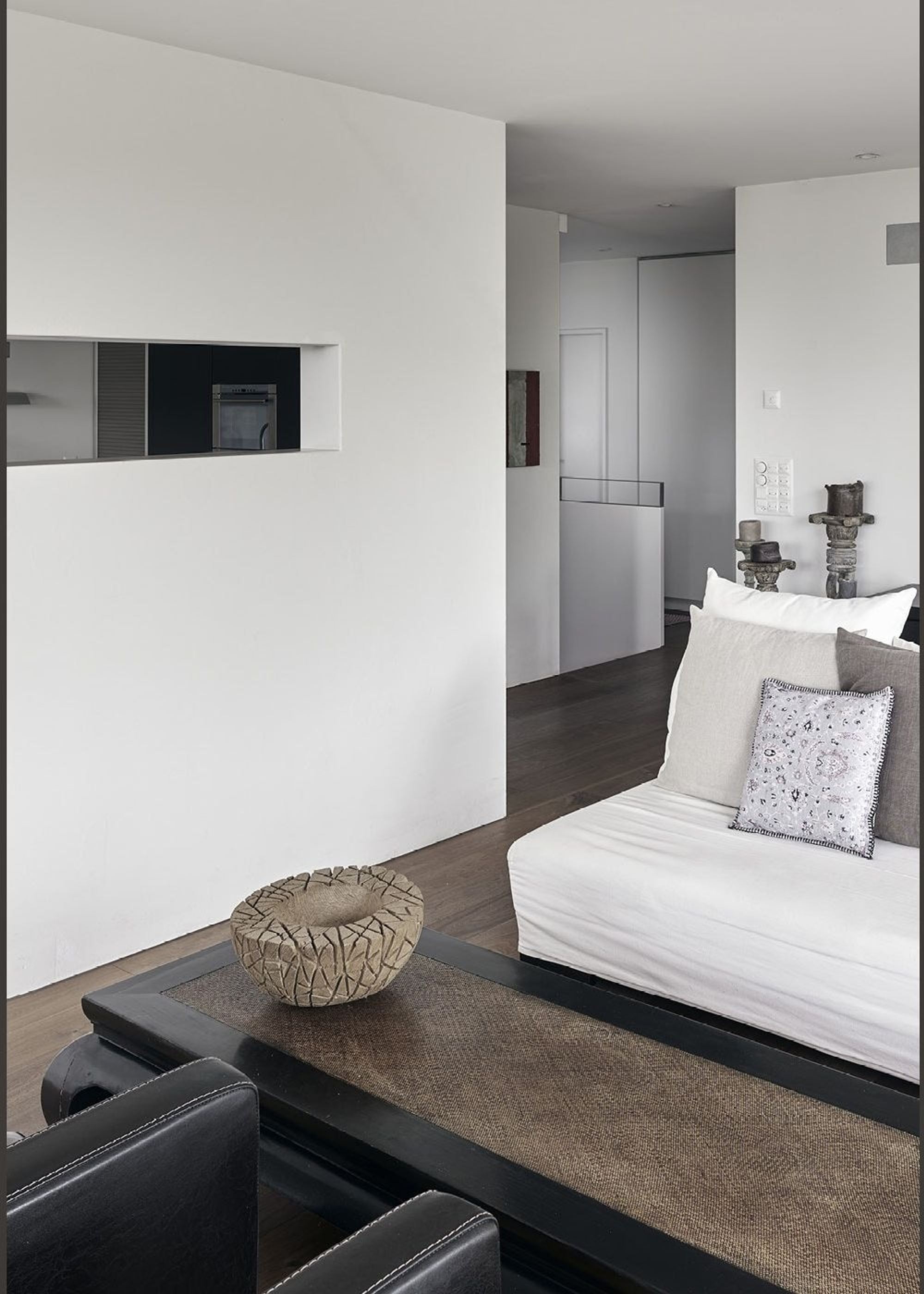 White sofa with view into the hallway – Apartment building in Uitikon