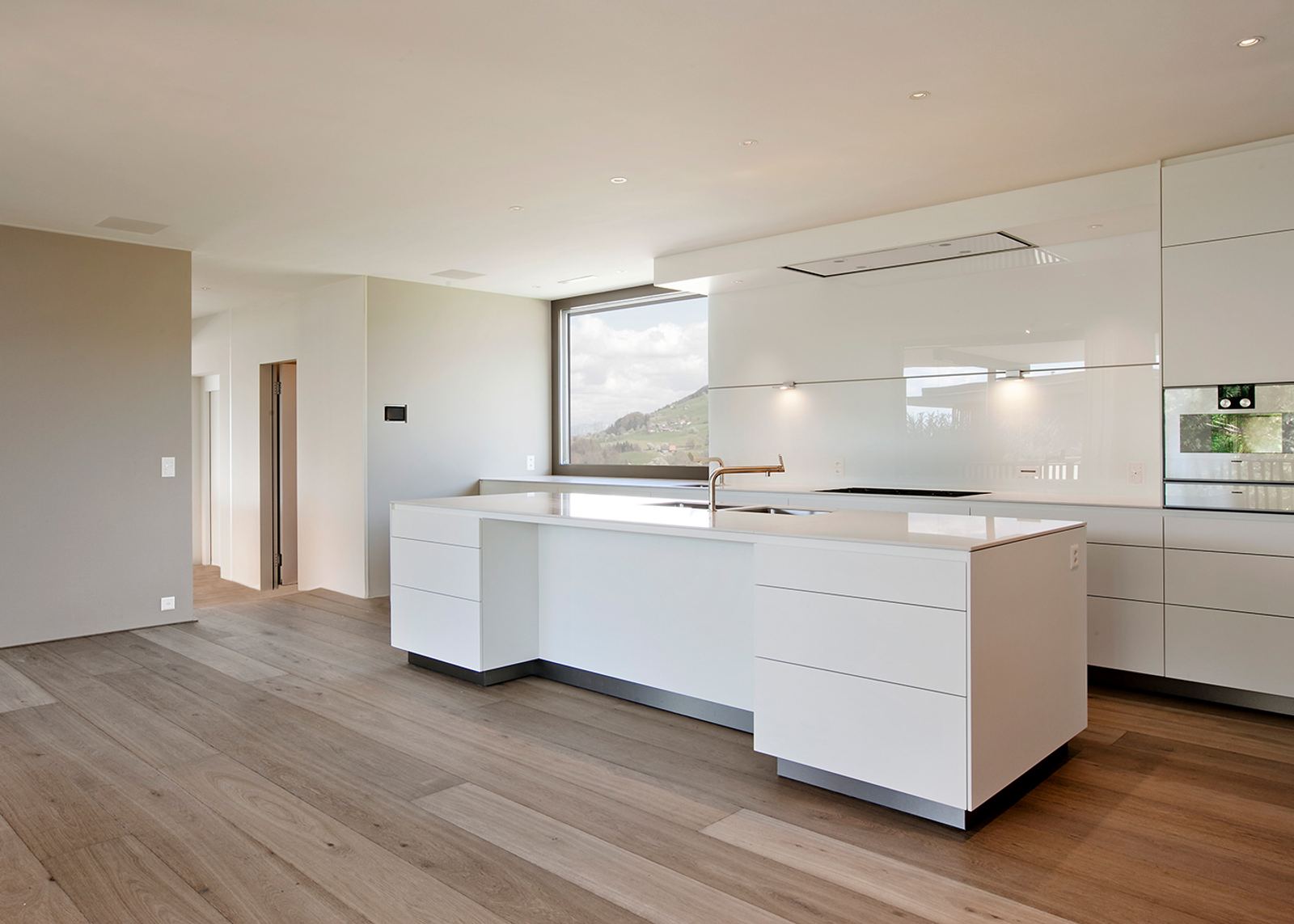 White kitchen with island on oak floor
