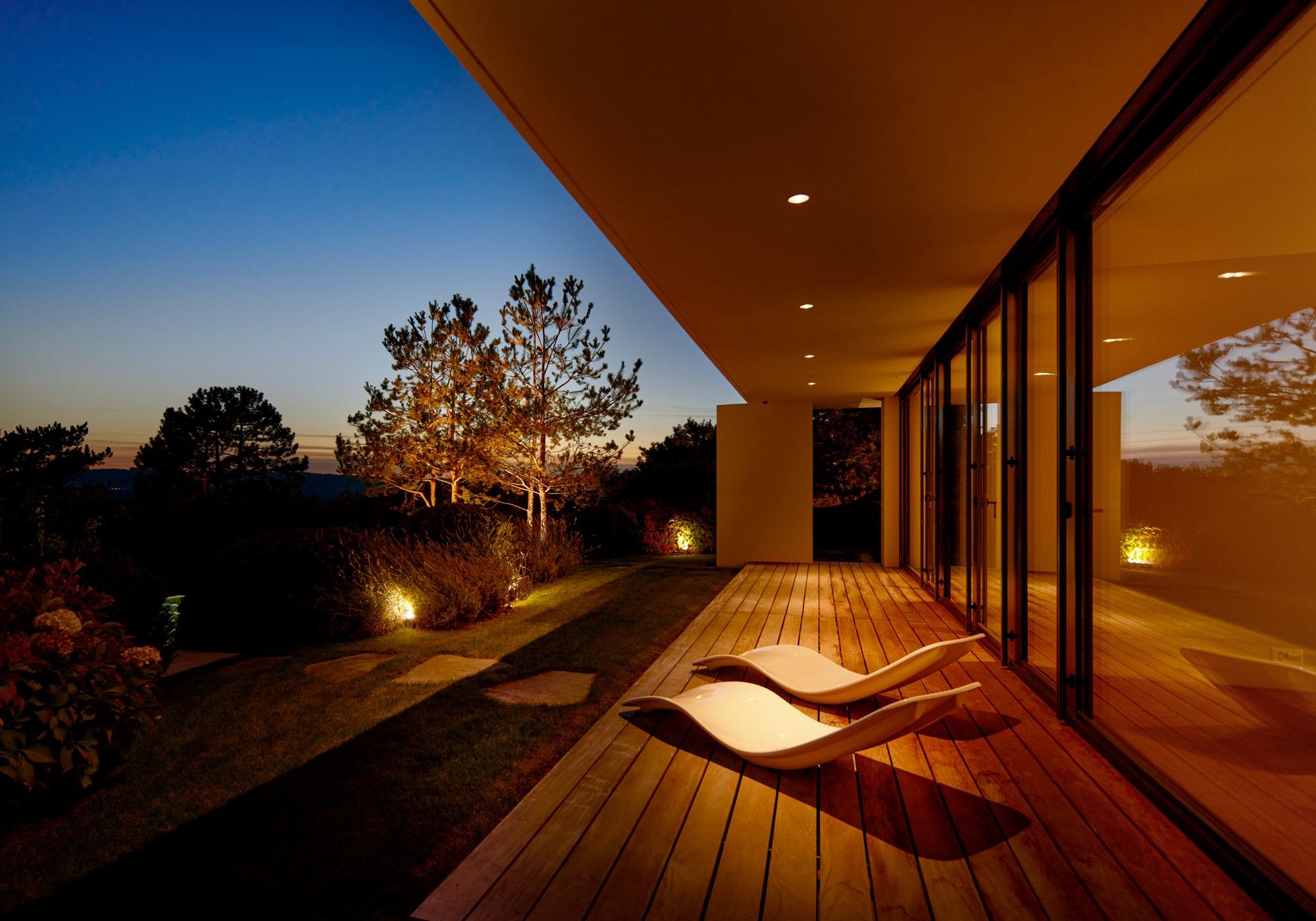 Covered terrace with timber deck and loungers in the evening – Single-family house in Uitikon