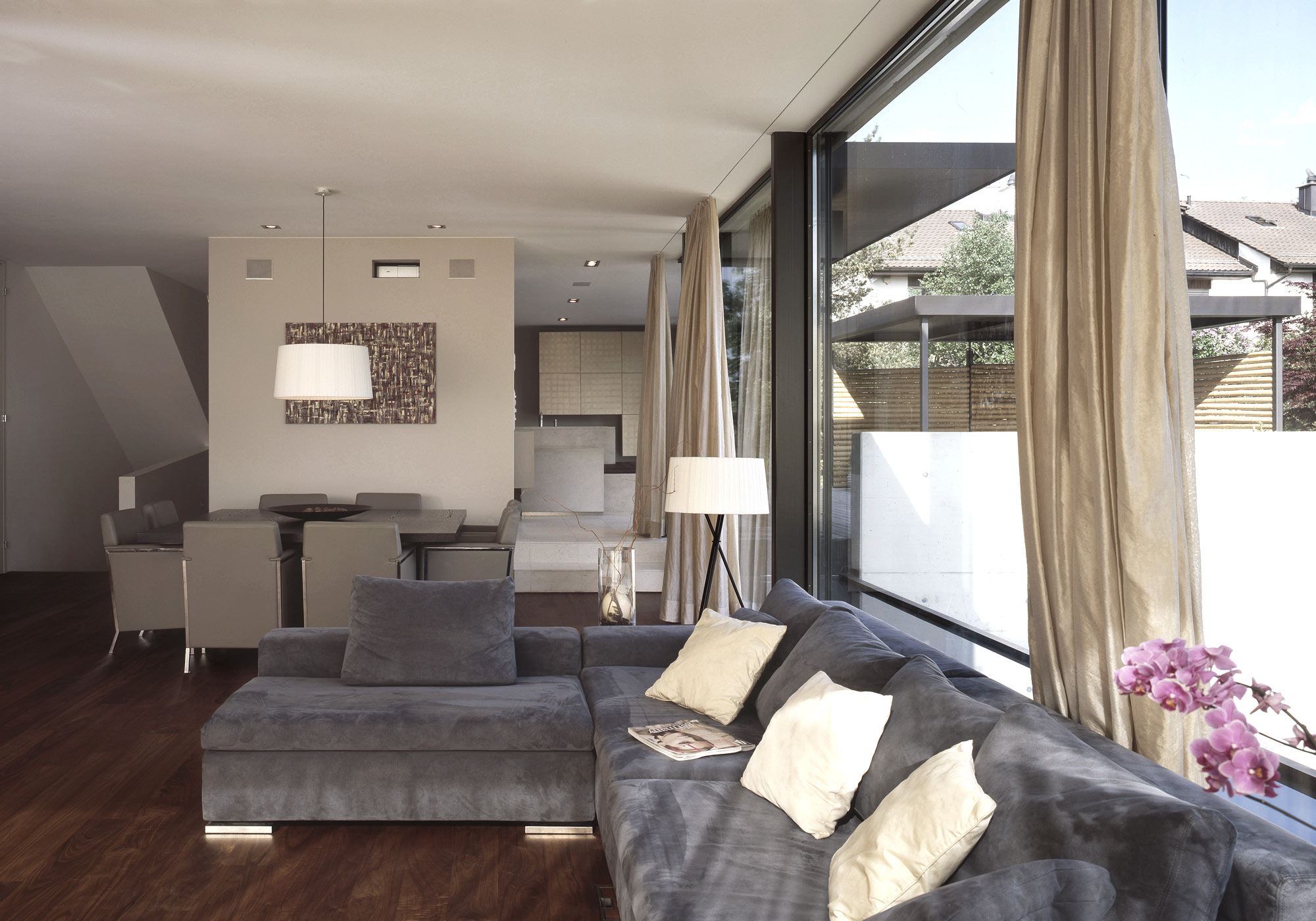 Living room with grey sofa and dining area – Single-family house in Uitikon