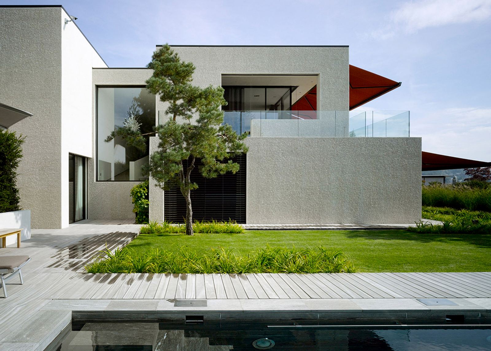 Pine and water basin in front of a cubic house