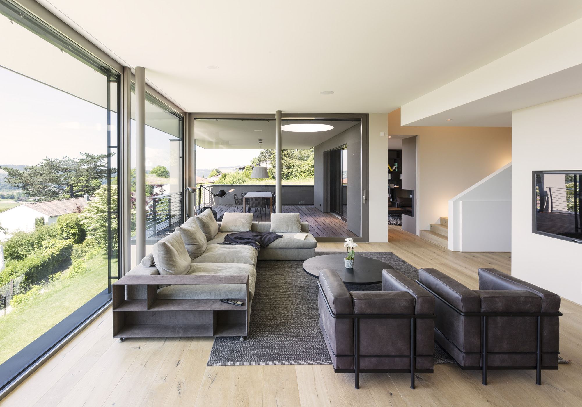 Living room with large sofa and glass front – Single-family house in Uitikon
