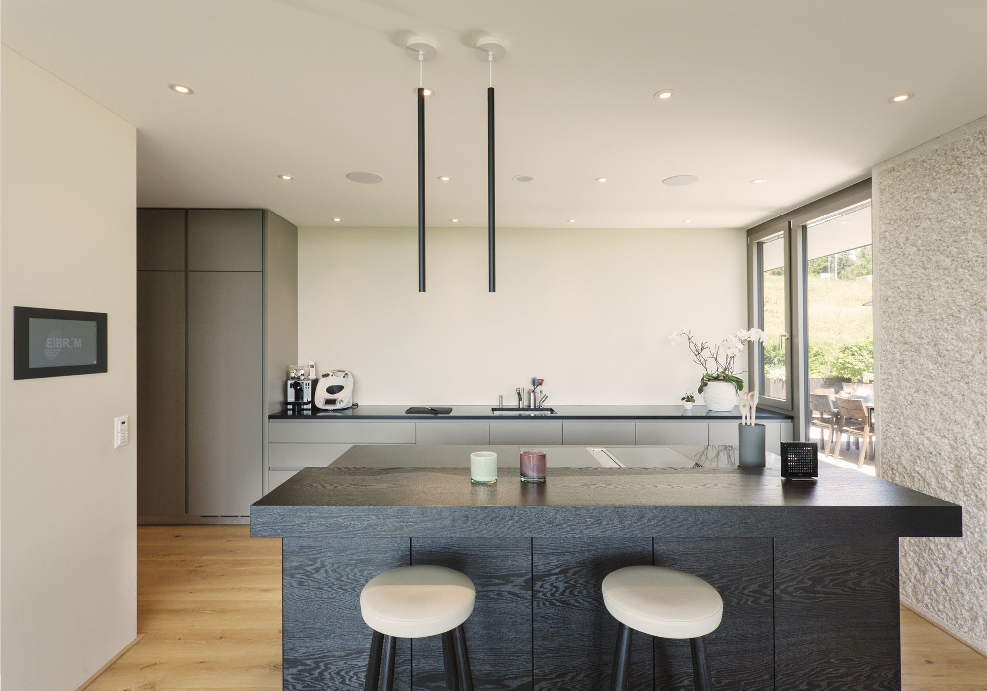 Kitchen with dark island and bar stools – Single-family house in Uitikon