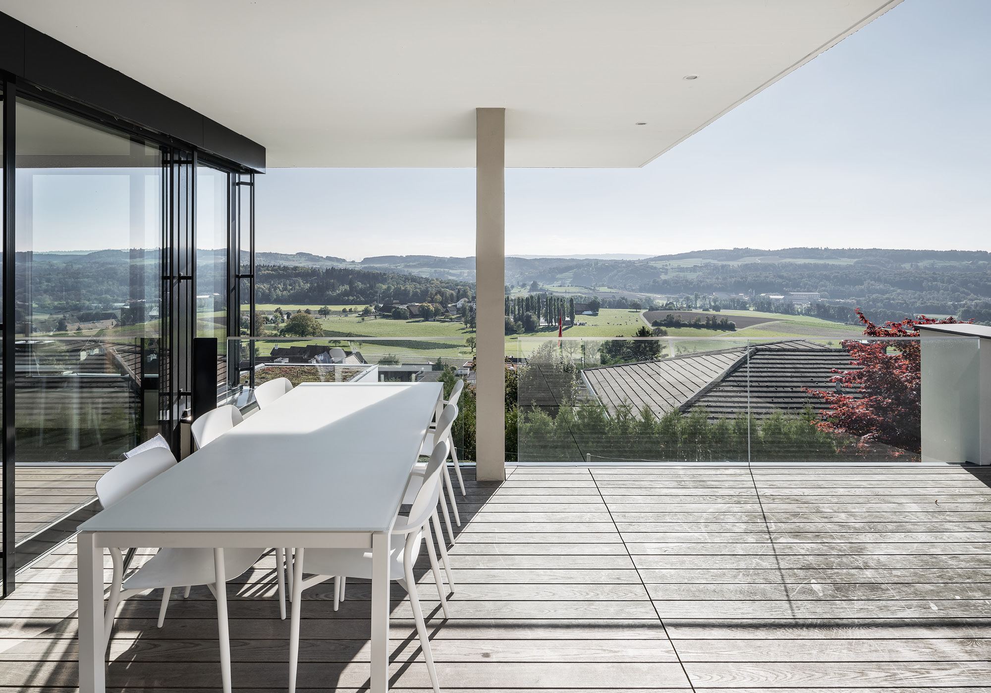 Covered terrace with dining table and wide view – Single-family house in Uitikon