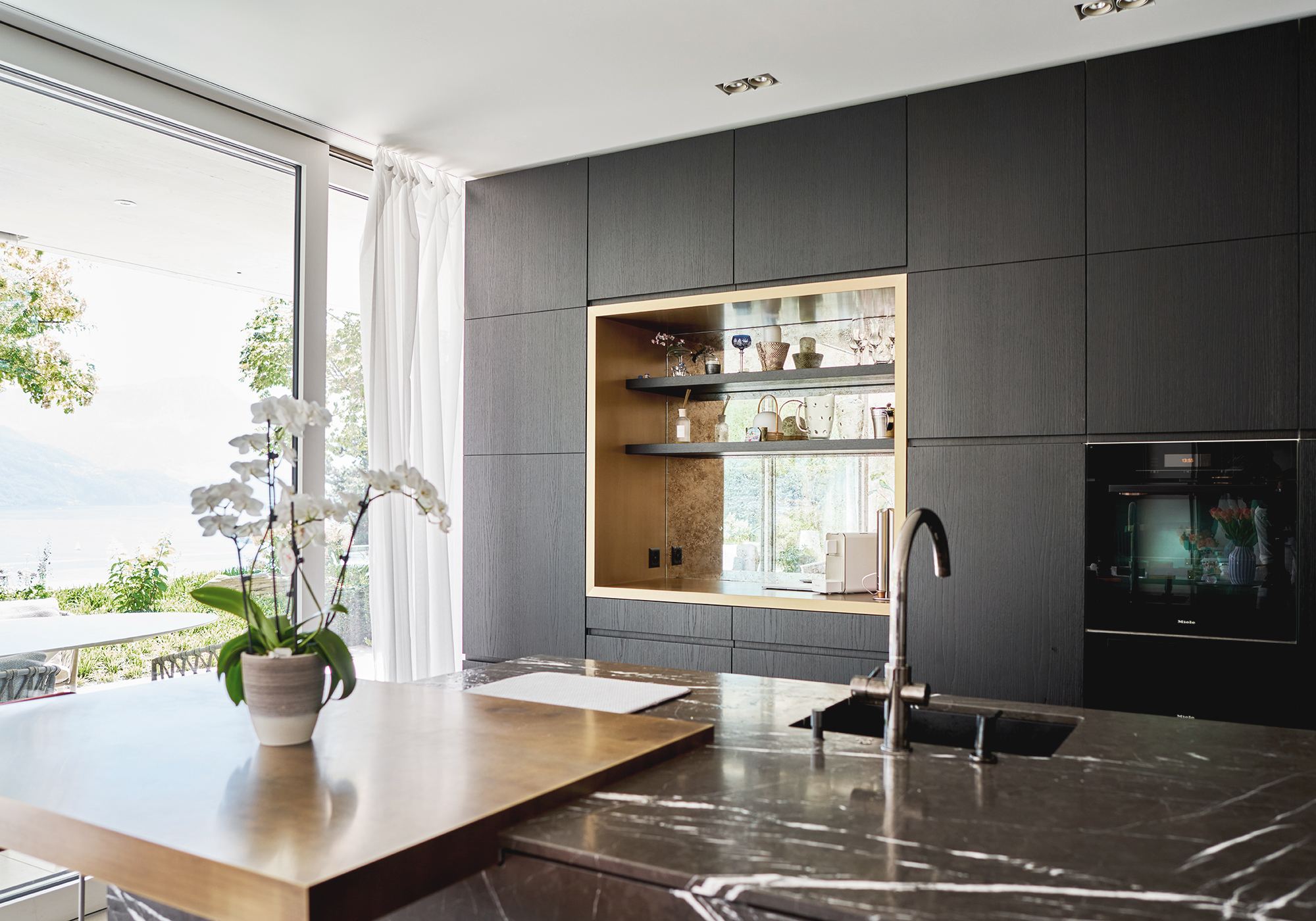 Kitchen island with timber top and lit niche – Interiors and landscape, Luzern