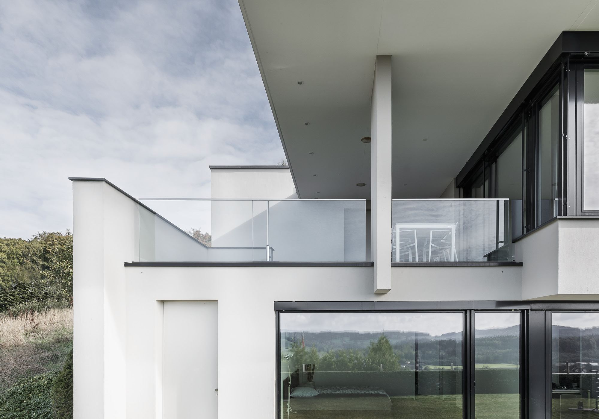Terrace with glass balustrade and column – Single-family house in Uitikon
