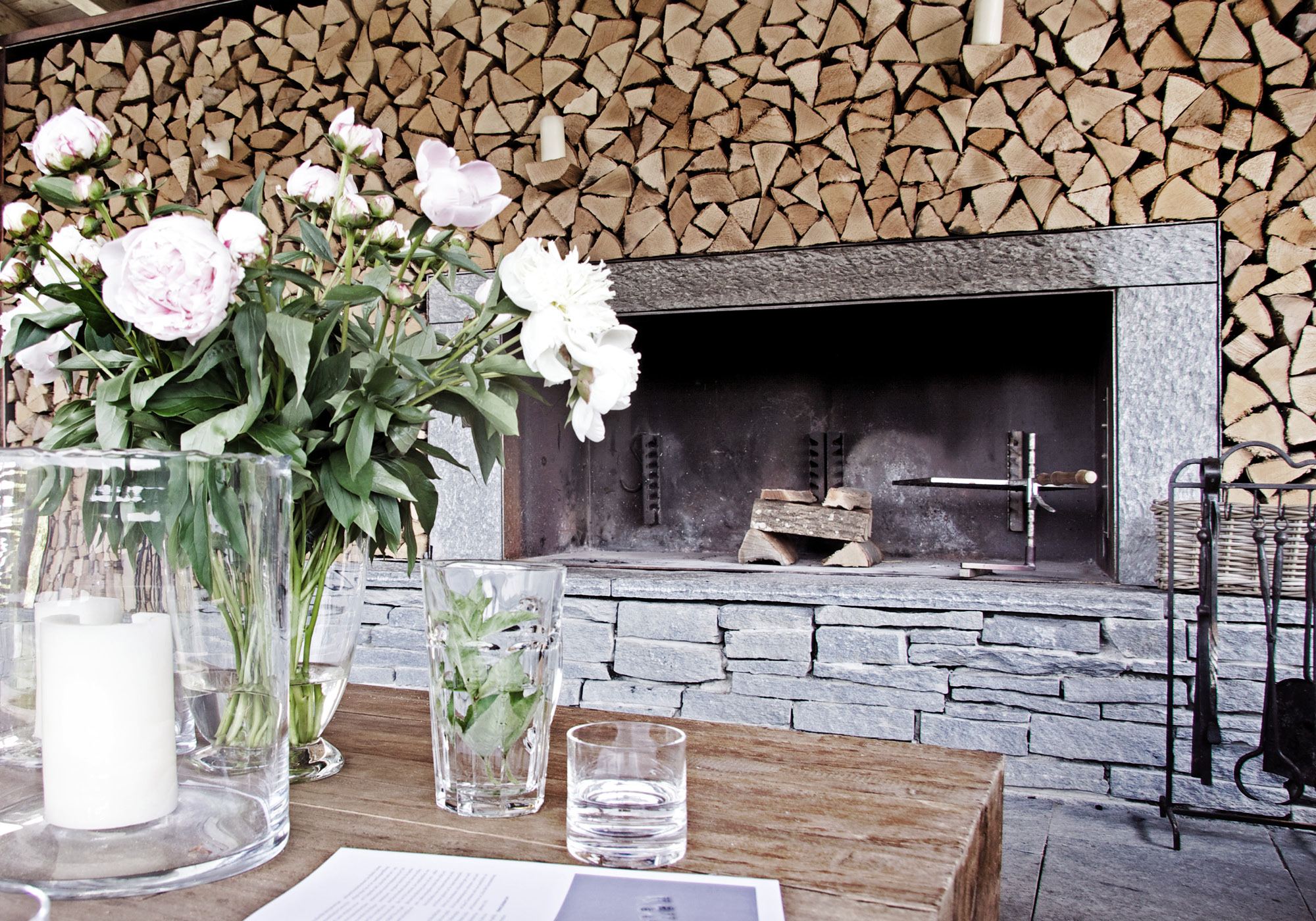 Outdoor fireplace with peonies and firewood wall – Interiors and landscape, Stallikon