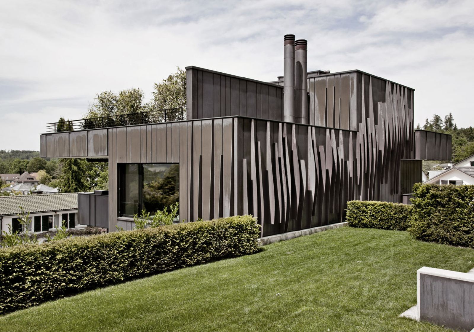 Dark metal facade above the lawn