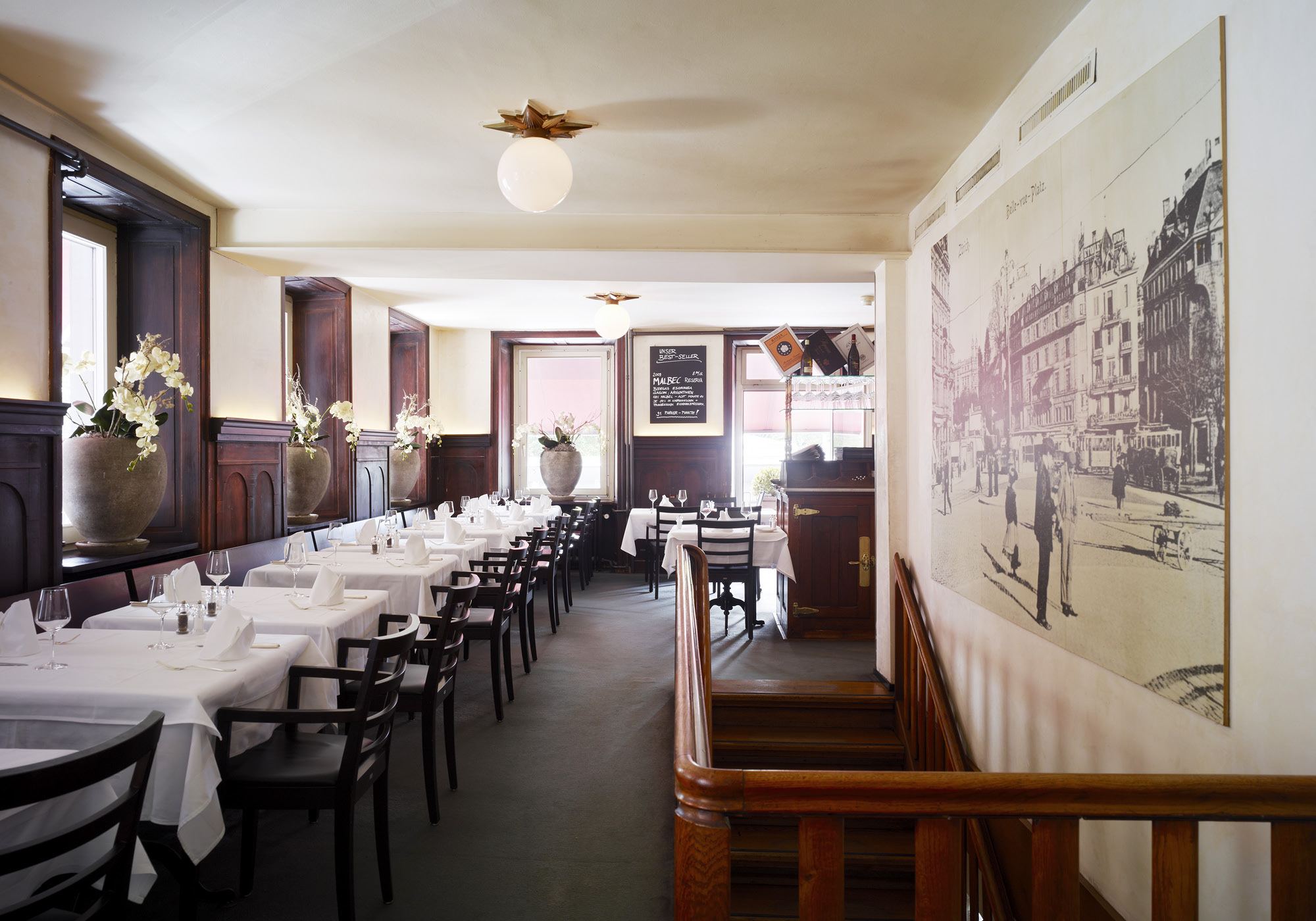 Long dining room with white tablecloths – Interiors and landscape, Zürich
