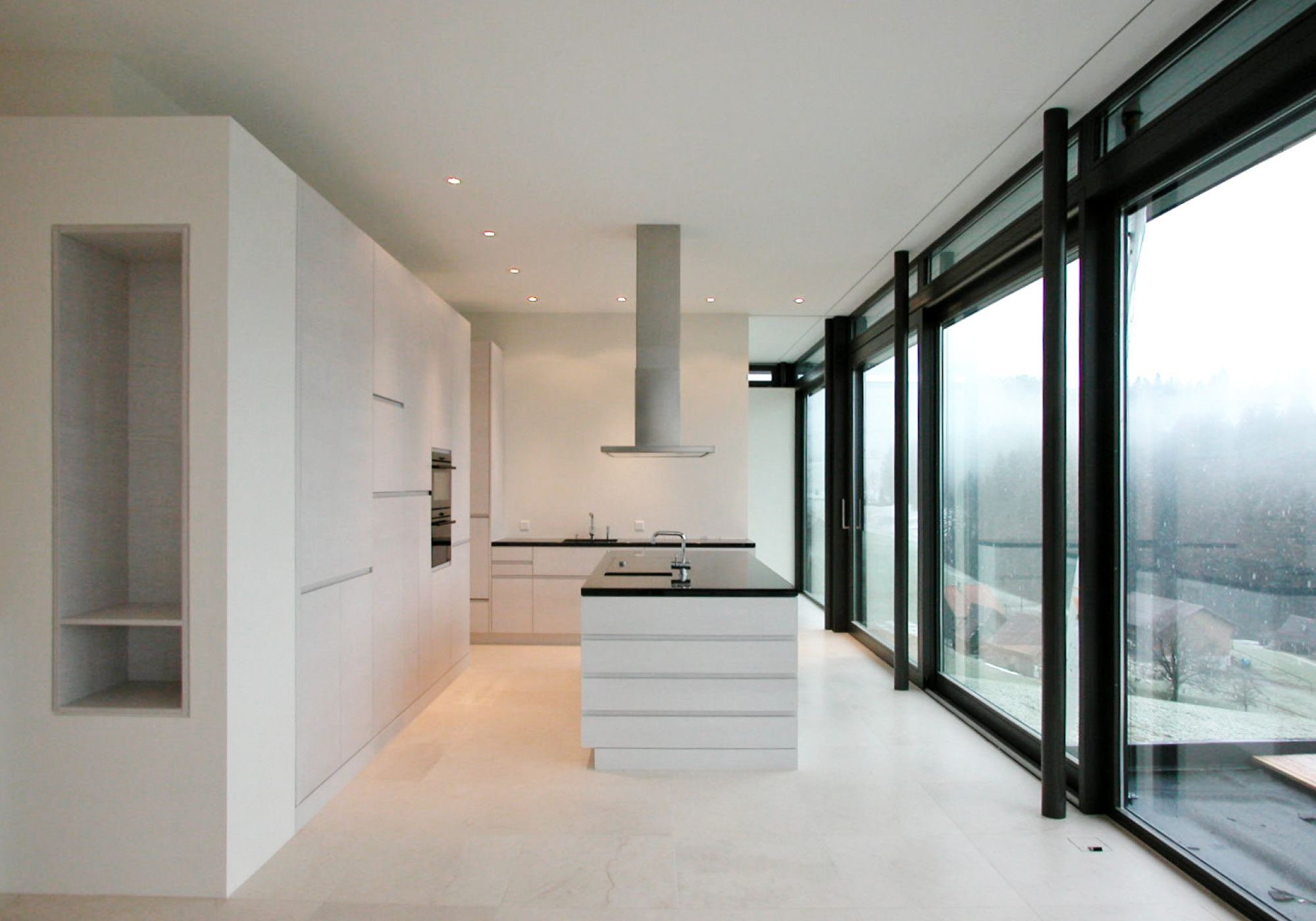 White kitchen with island and glass front – Single-family house in Teufen