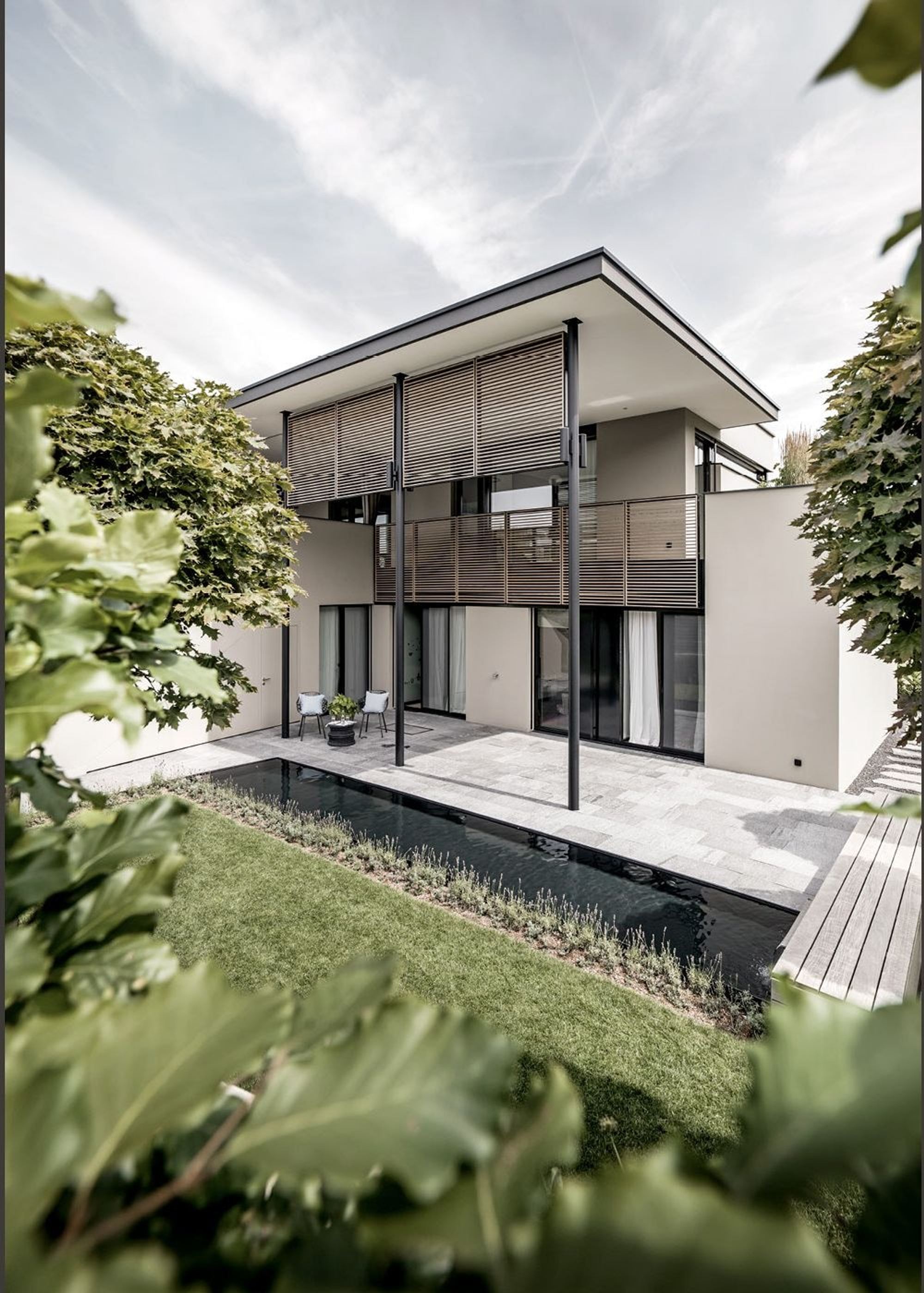 Garden facade with timber louvres and water basin – Single-family house in Schindellegi
