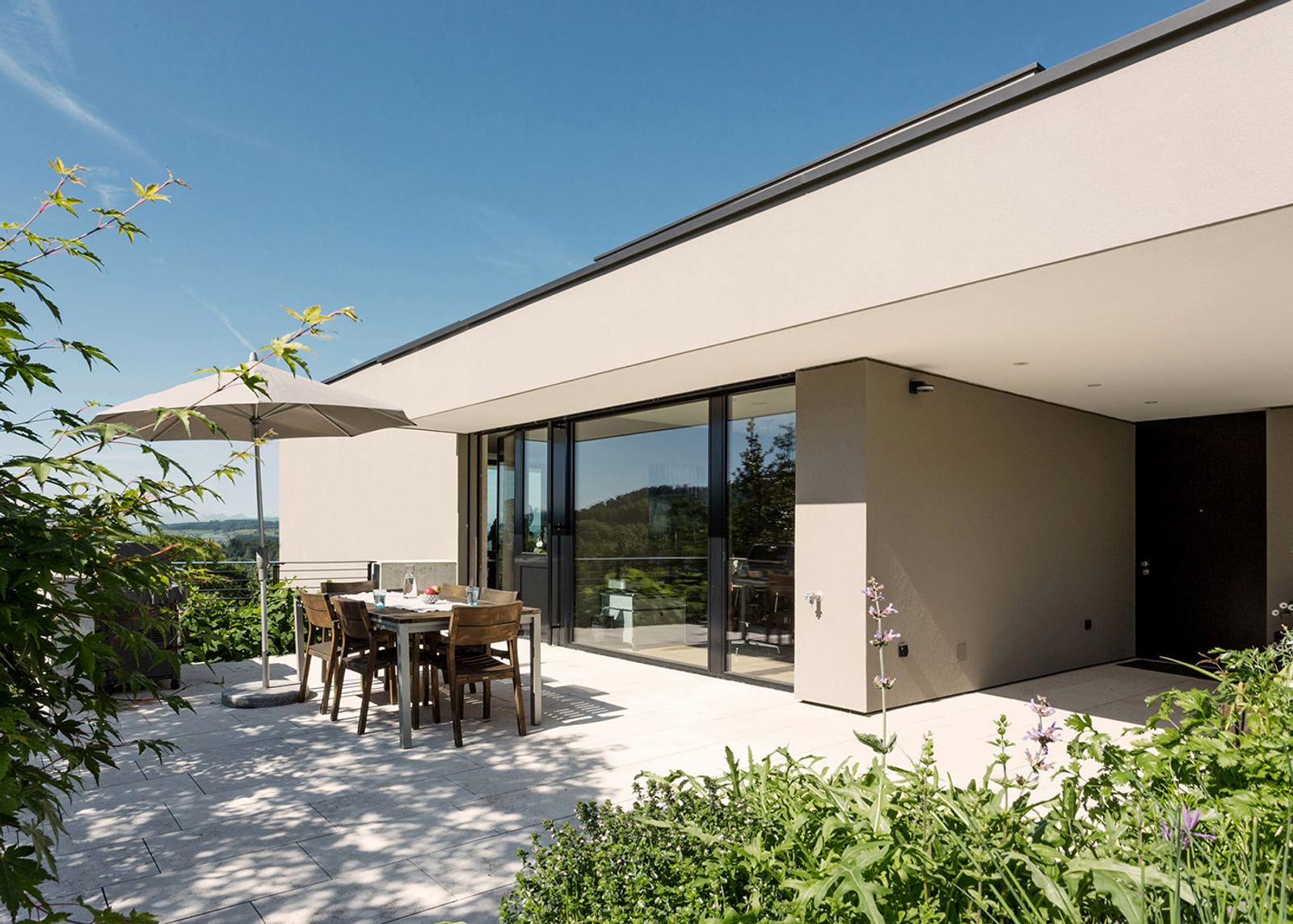Seating area with parasol by the glass front