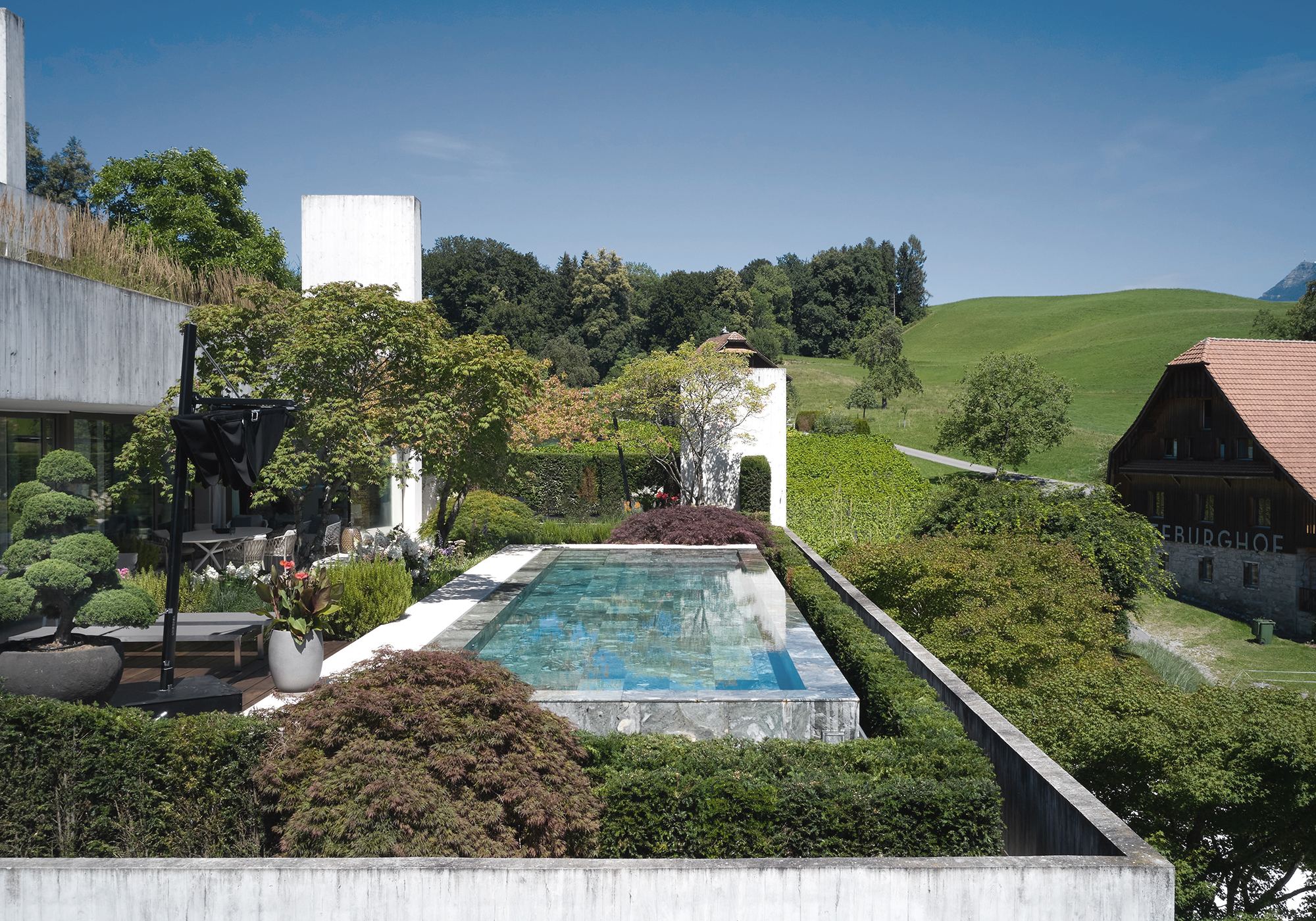 Pool with topiary and view of the countryside – Interiors and landscape, Luzern