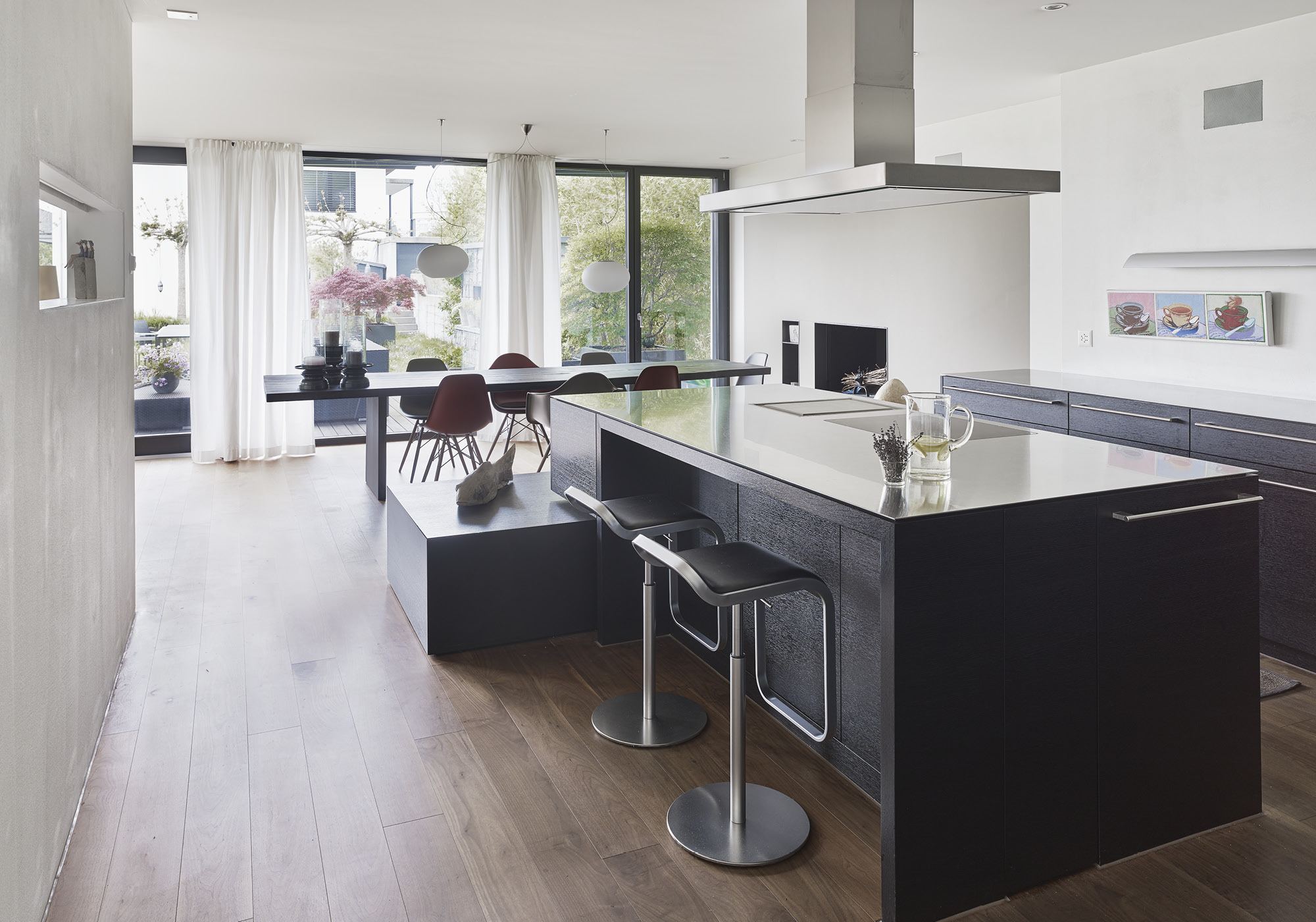 Open kitchen with island and bar stools – Apartment building in Uitikon