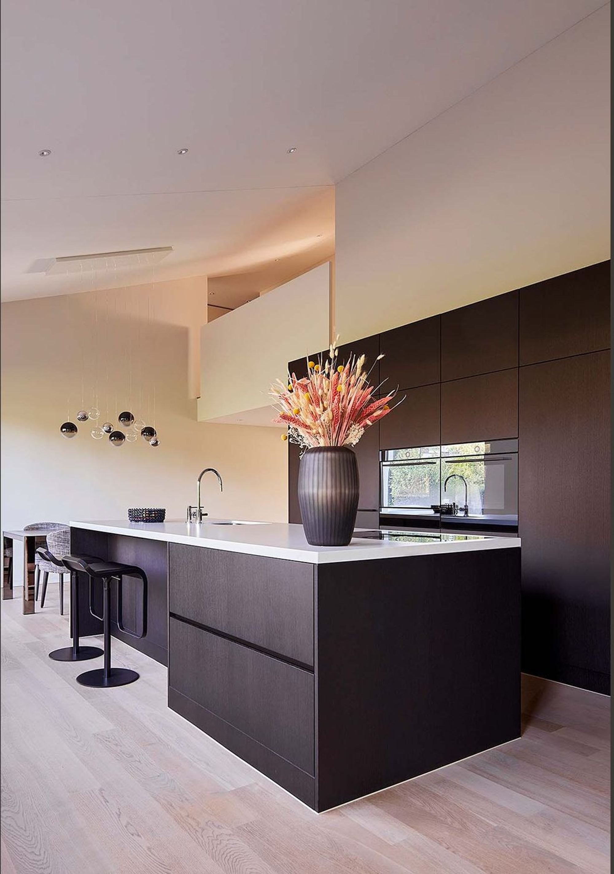 Kitchen island with dark fronts and bar stool – Interiors and landscape, Zumikon