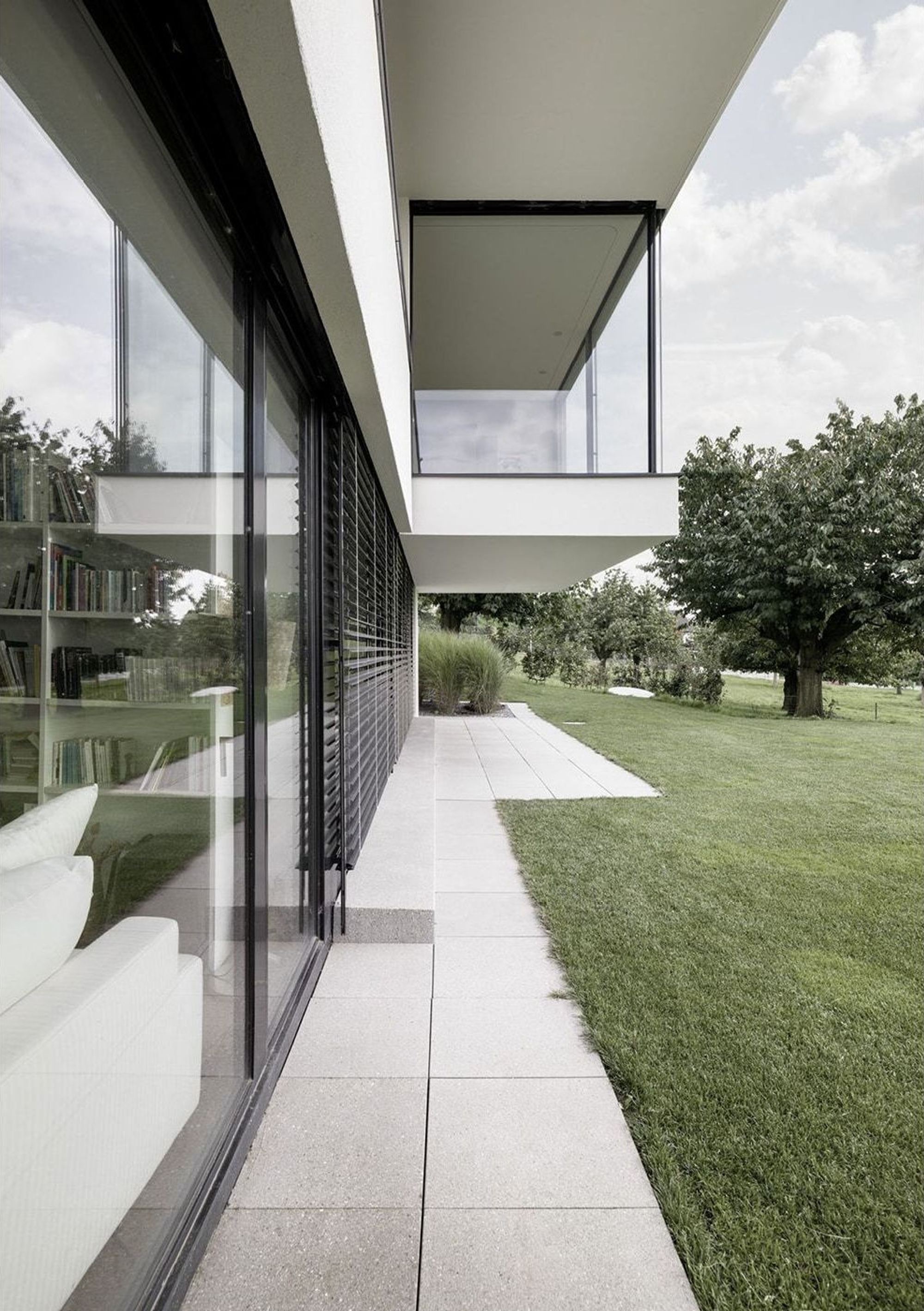 Paved path under the canopy along the glass front – Single-family house in Uitikon