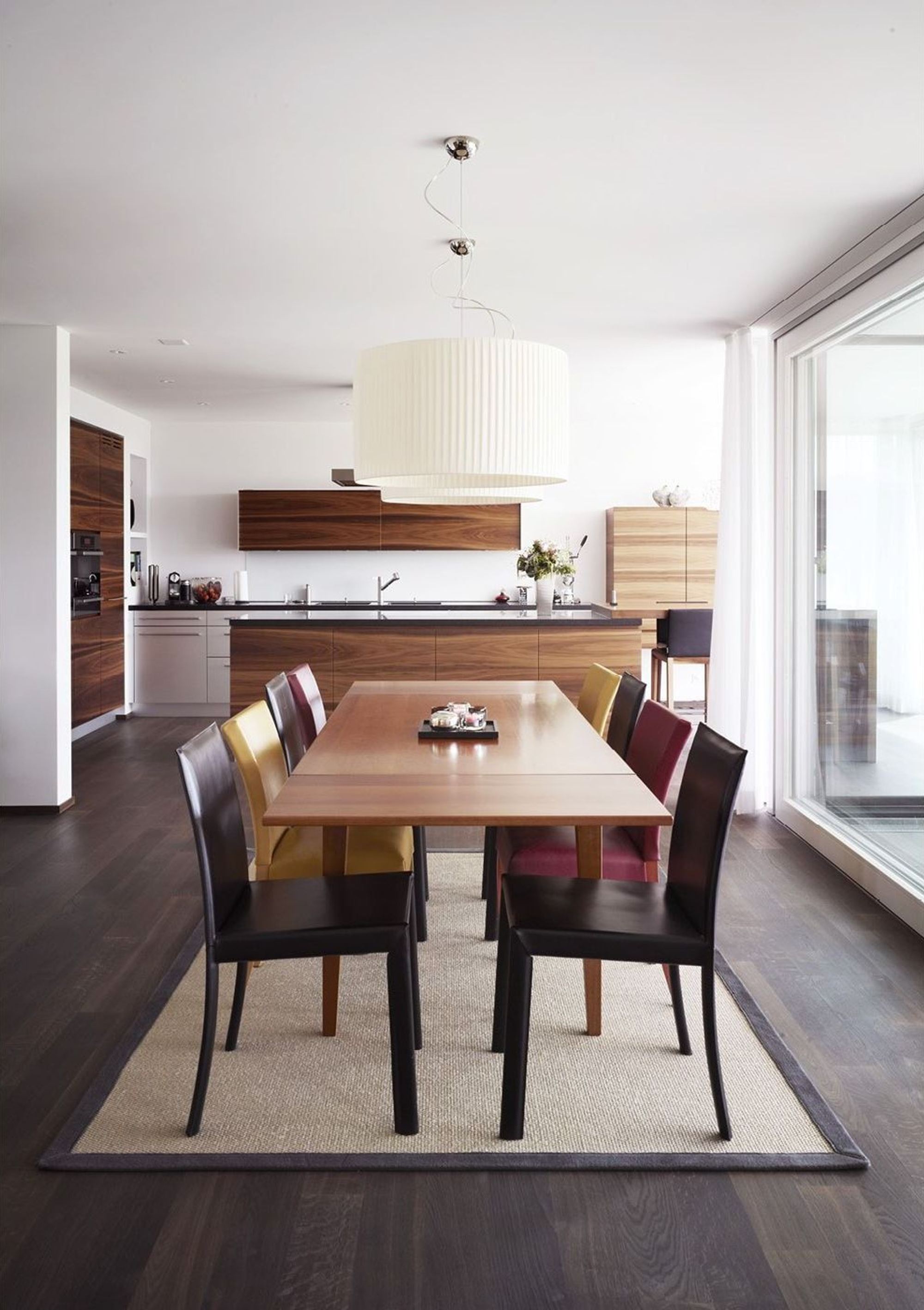 Dining table with pendant light and open kitchen – Single-family house in Russikon