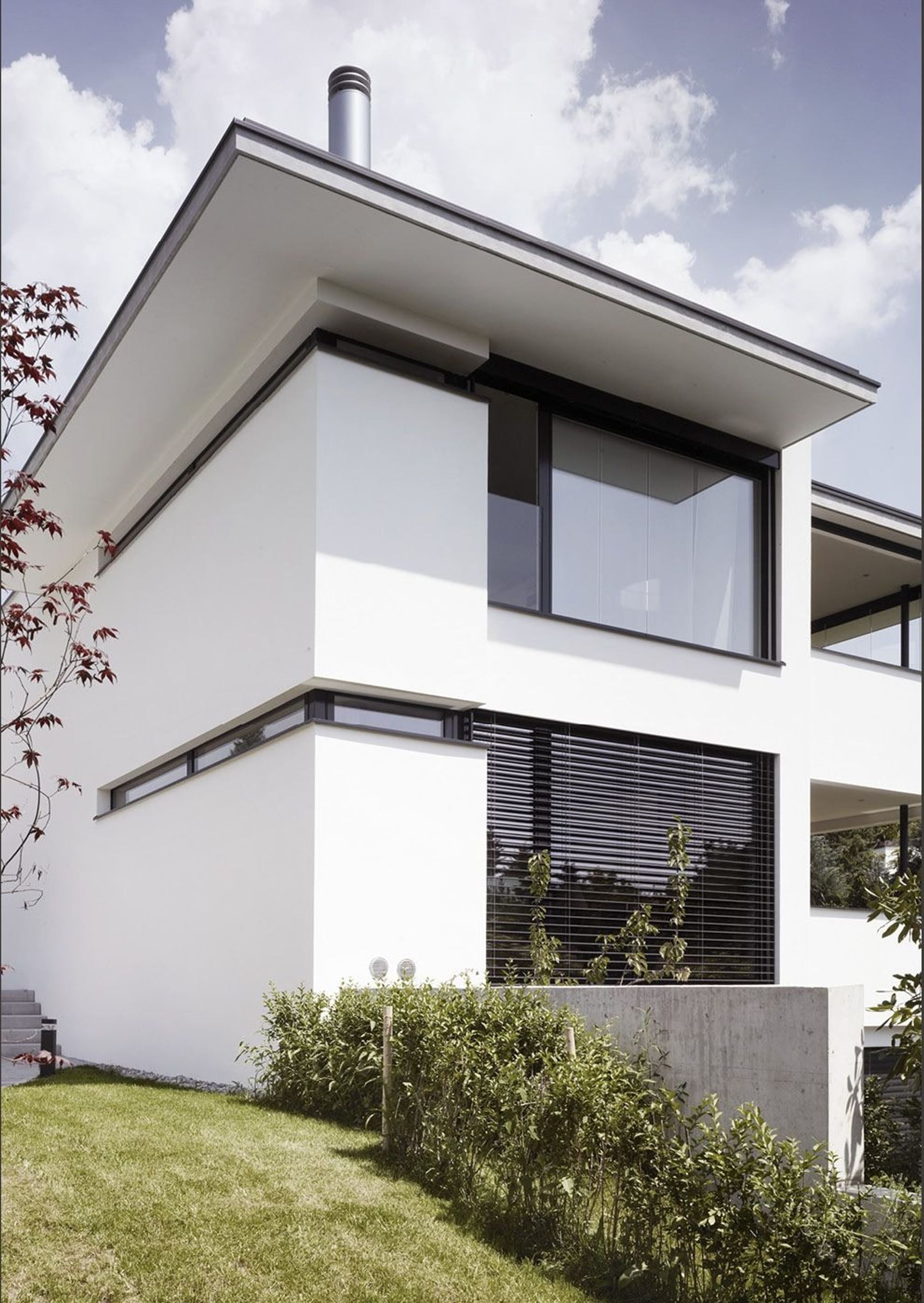 White facade with cantilevered roof – Apartment building in Uitikon