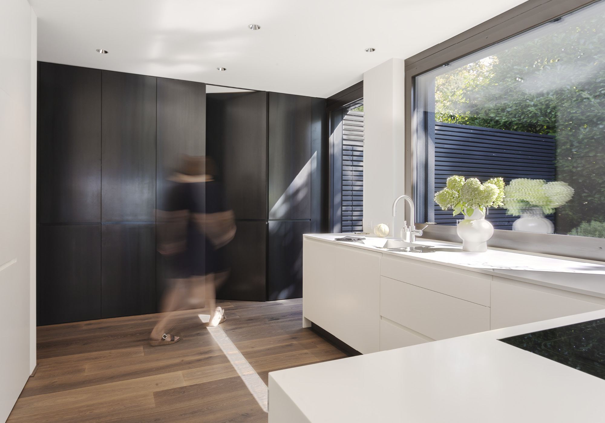 Kitchen with white island and dark cabinetry – Single-family house in Meilen