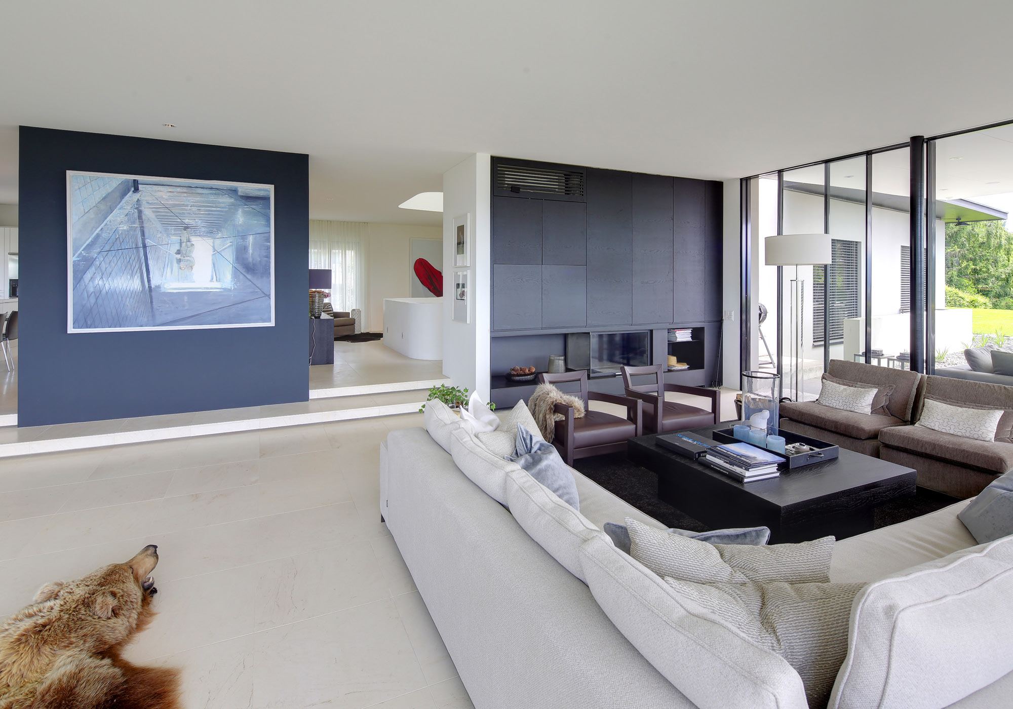 Seating group with fireplace and blue wall – Single-family house in Meilen