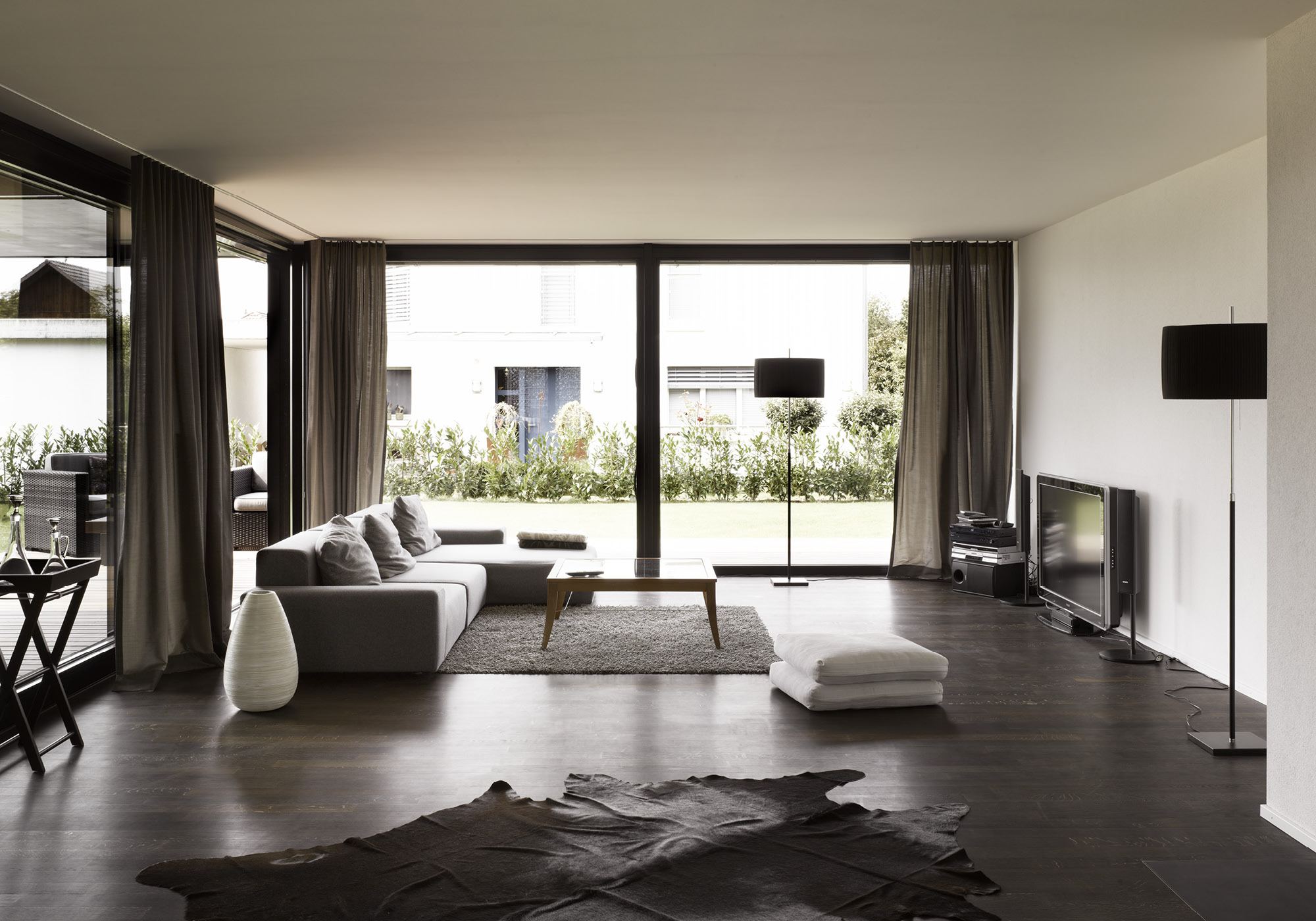 Living room with corner sofa and hide on dark floor – Single-family house in Möriken