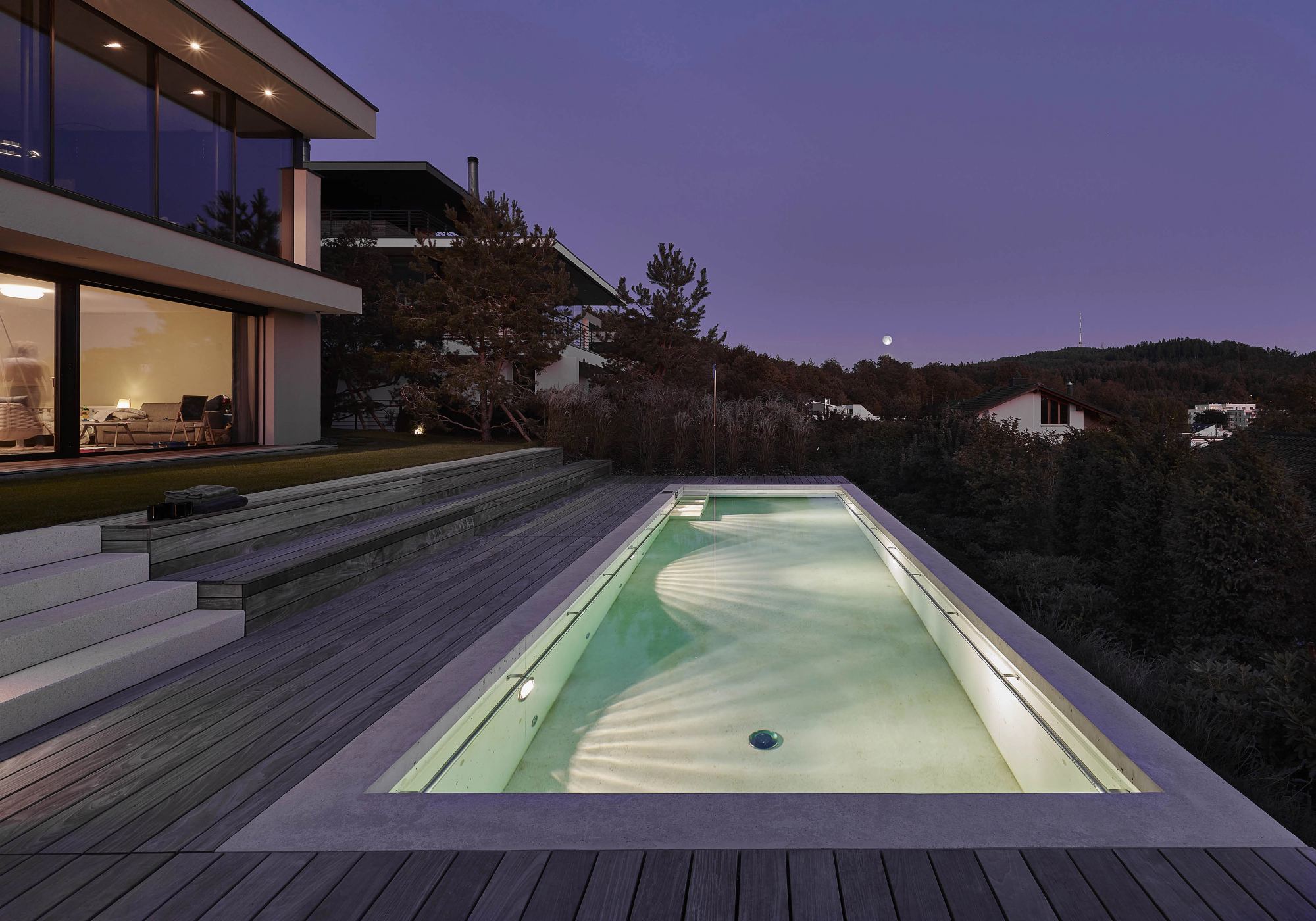 Pool with seating steps in the evening – Single-family house in Uitikon