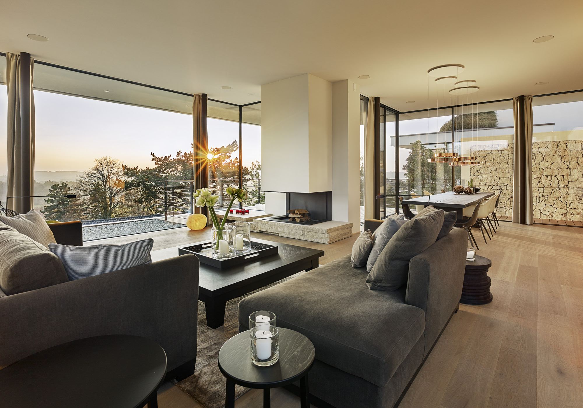 Living room with fireplace and open view at sunset – Single-family house in Uitikon