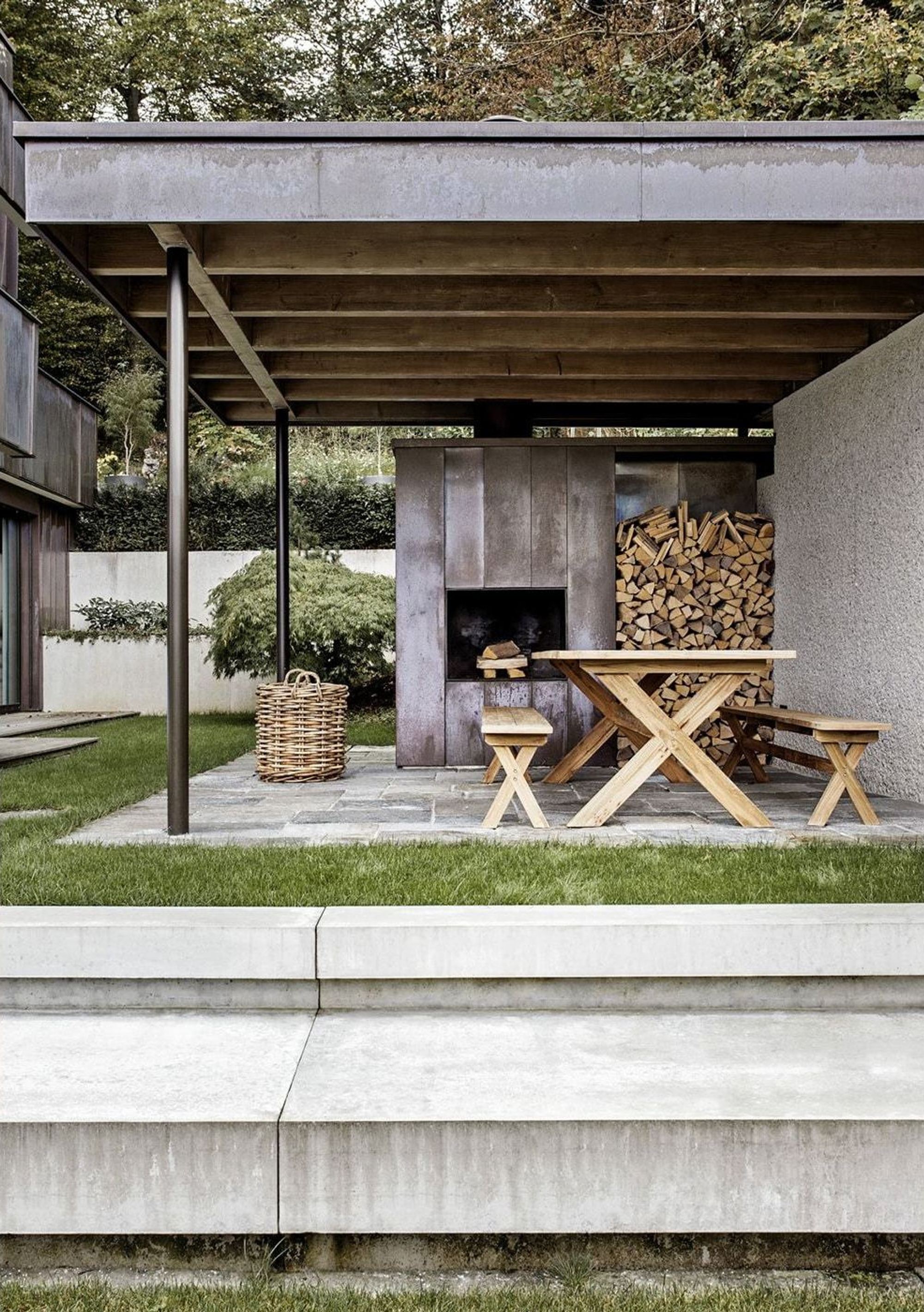 Covered seating area with timber table and firewood – Apartment building in Uitikon
