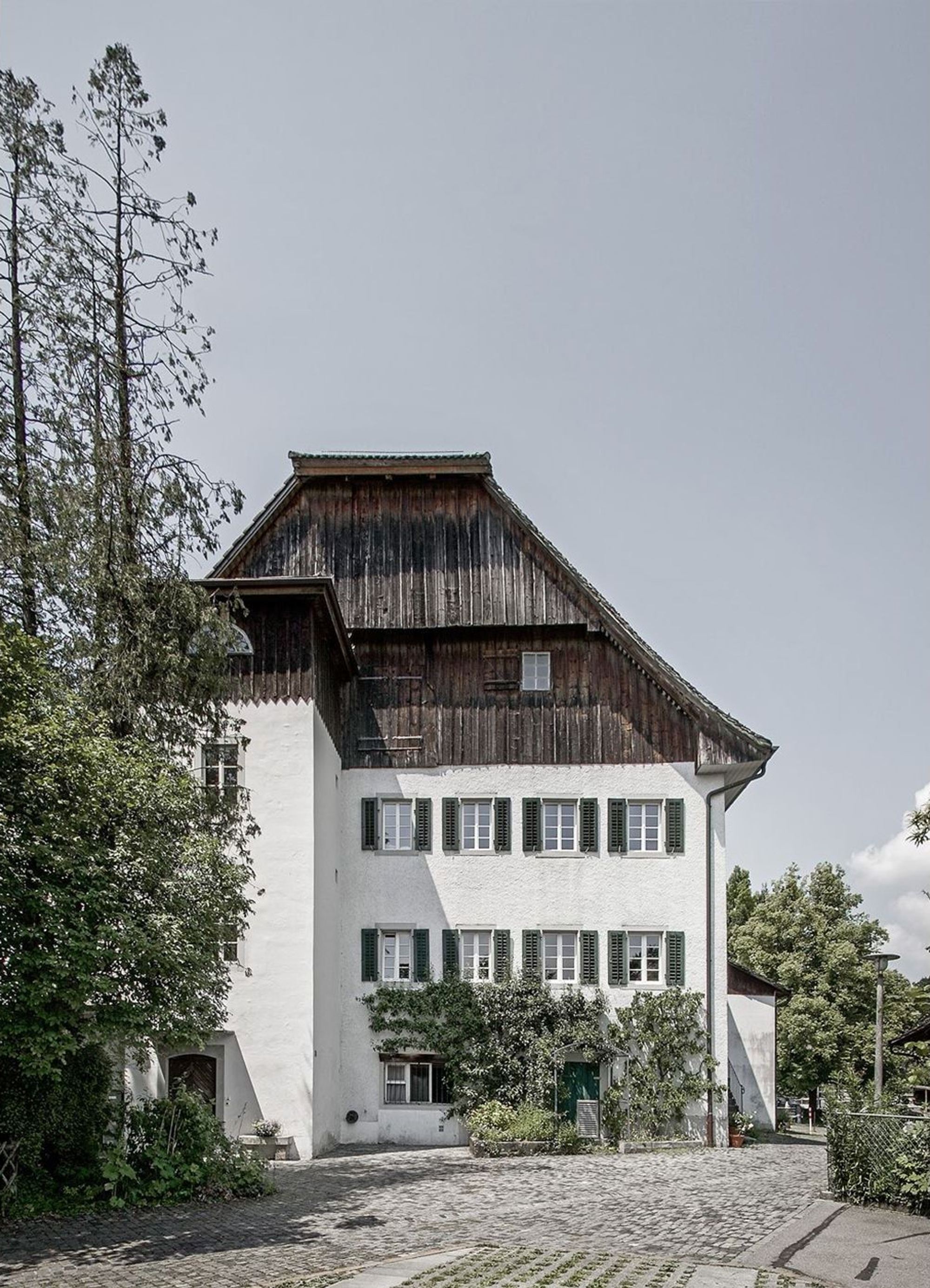 Giebelseite mit Holzverschalung und Fensterläden – Historischer Umbau in Uerikon