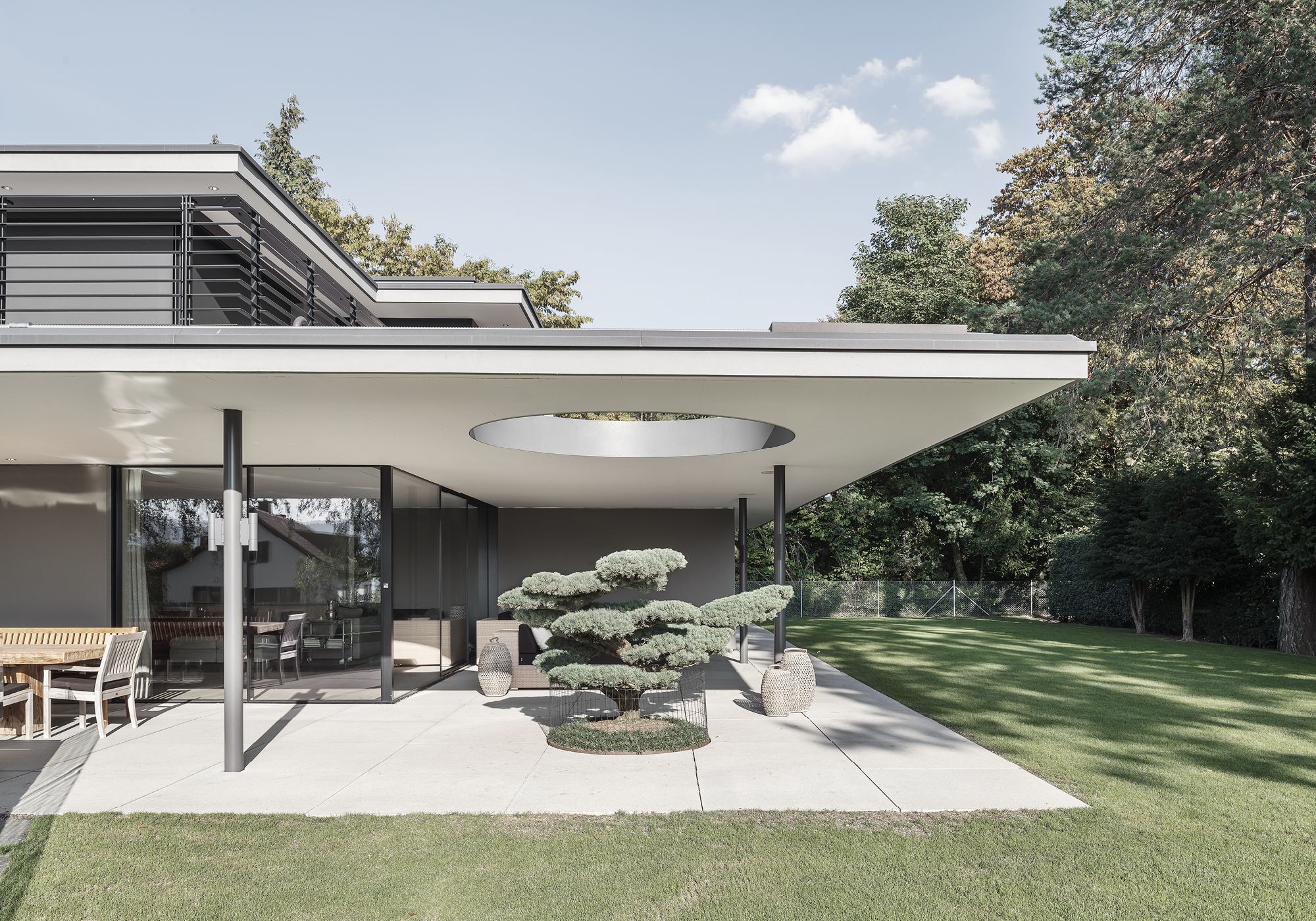 Covered terrace with circular opening in the canopy – Single-family house in Küsnacht