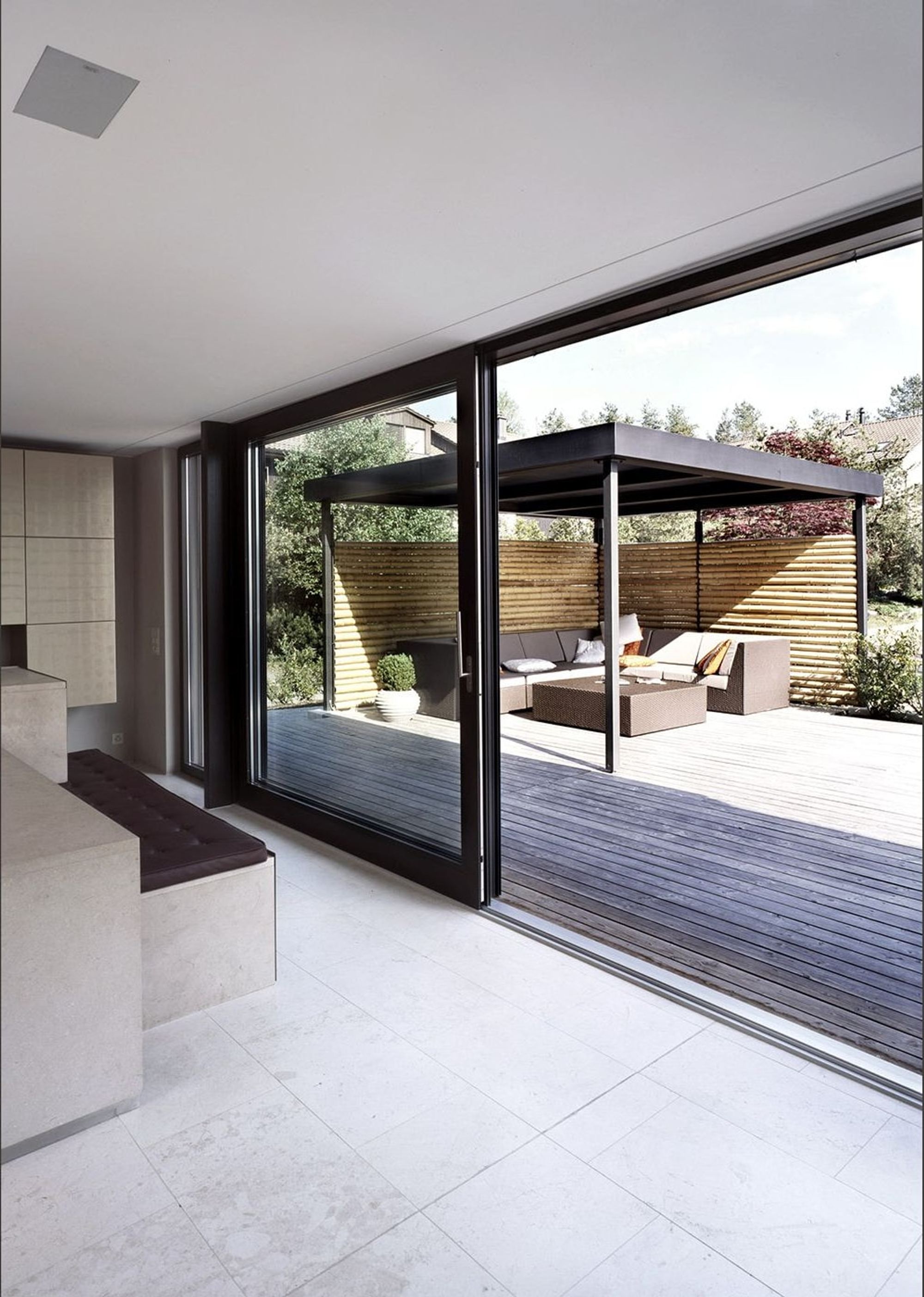 Sliding glass door to the timber terrace with pavilion – Single-family house in Uitikon