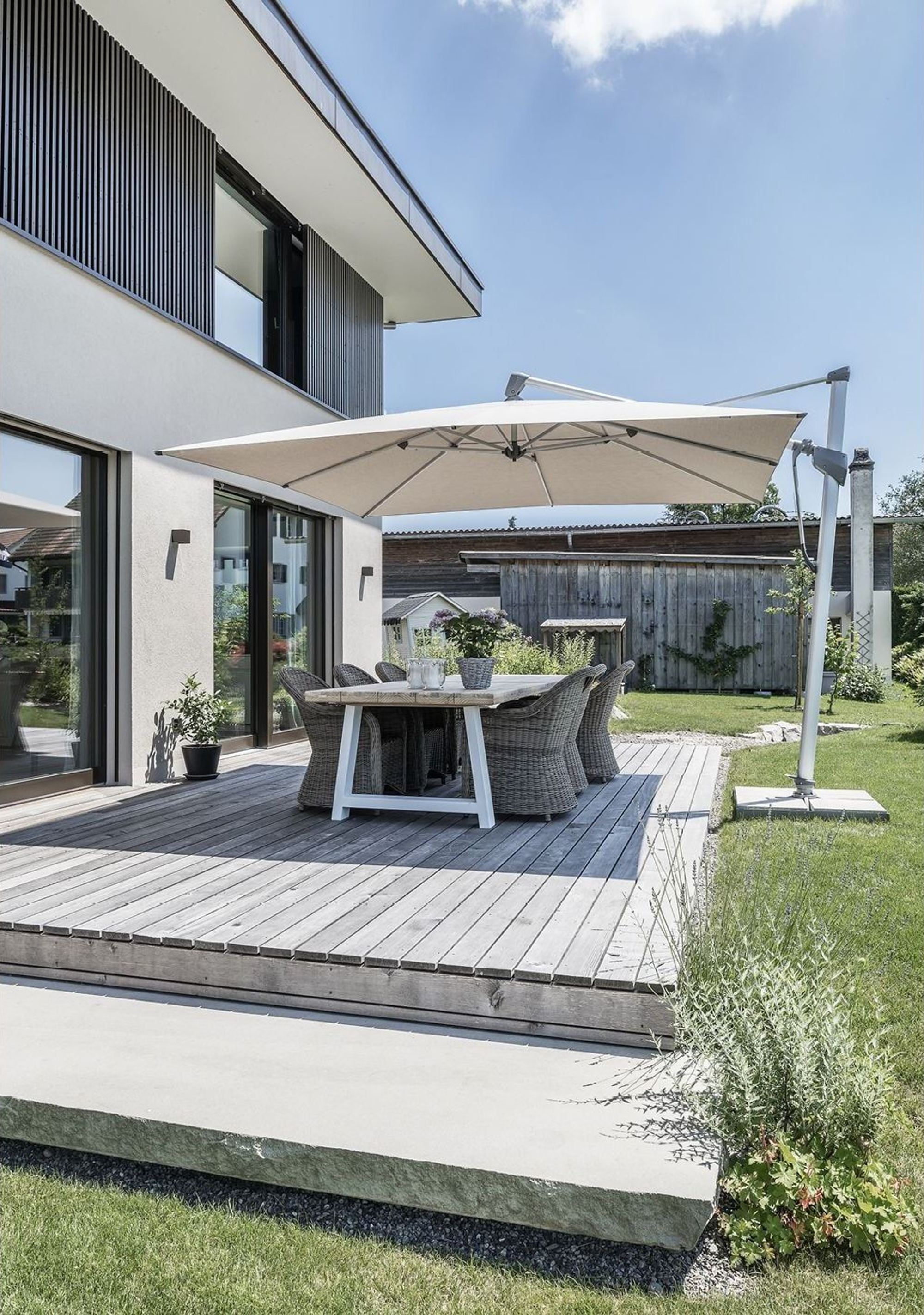 Timber terrace with dining table and parasol – Single-family house in Grüningen