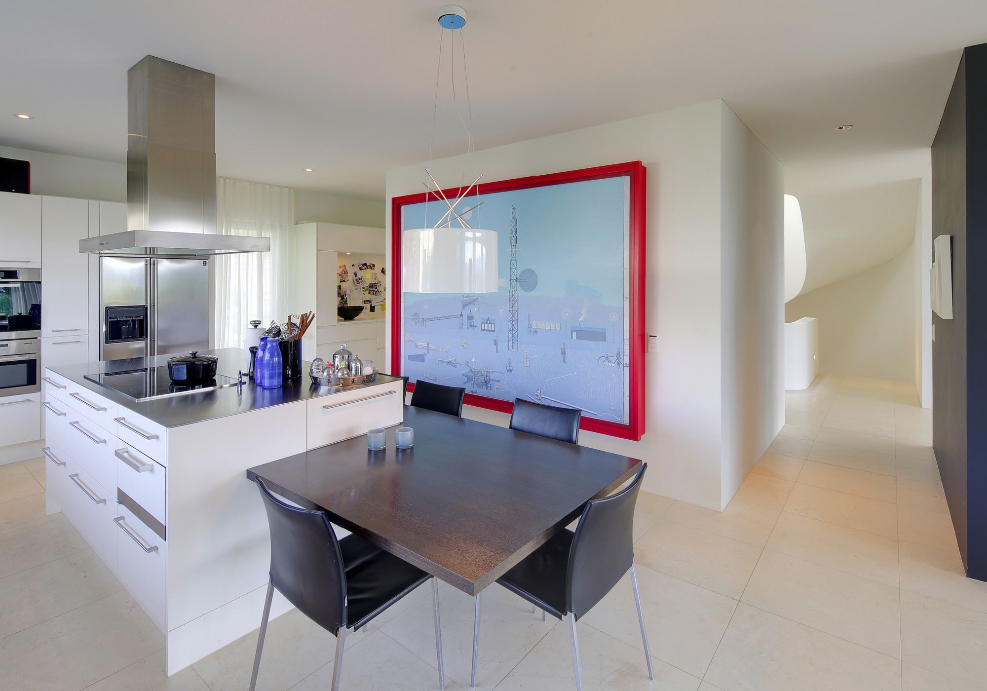 Kitchen with island and dining table in front of a large painting – Single-family house in Meilen