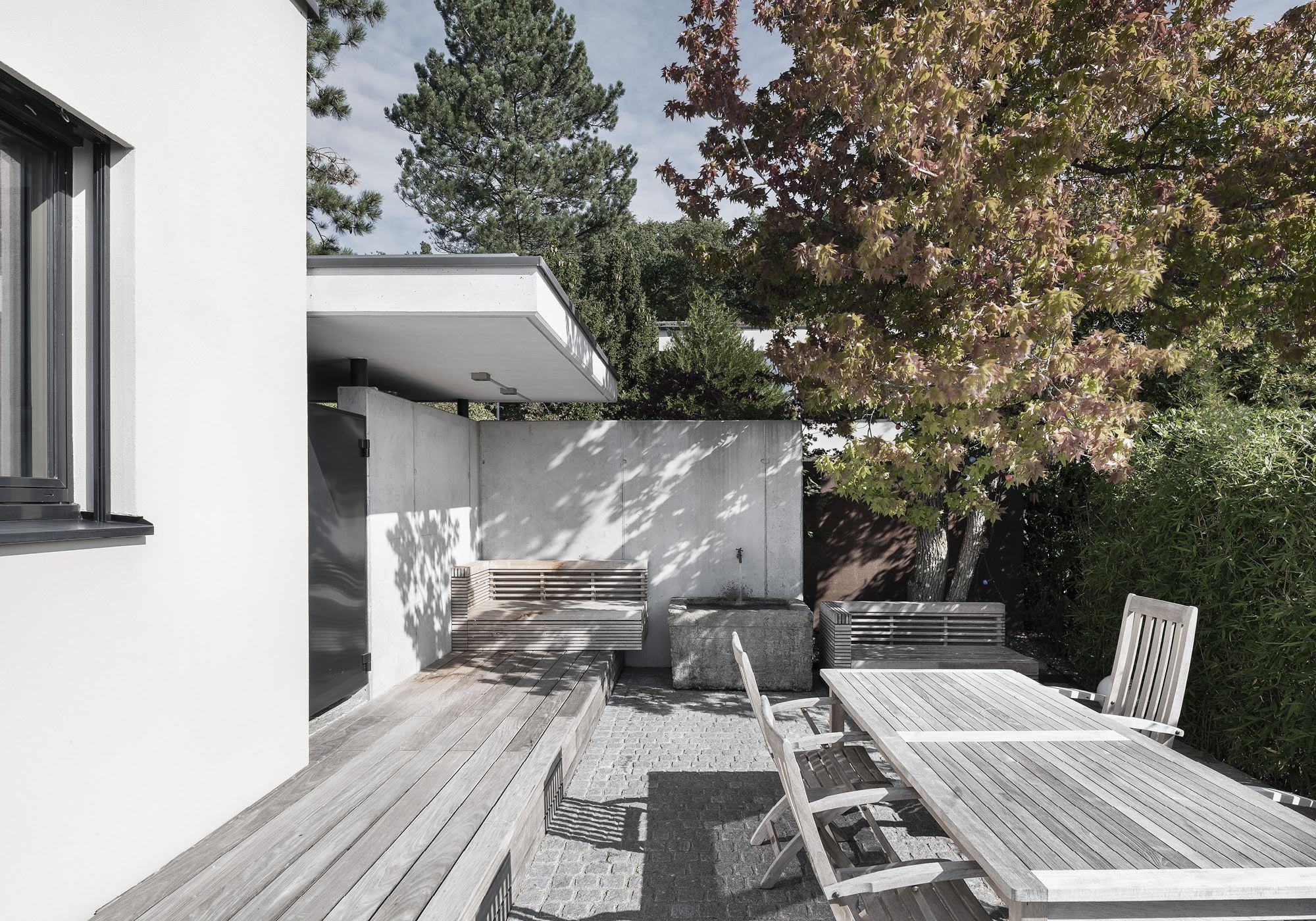 Timber deck with dining table and lounge in the garden – Single-family house in Uitikon