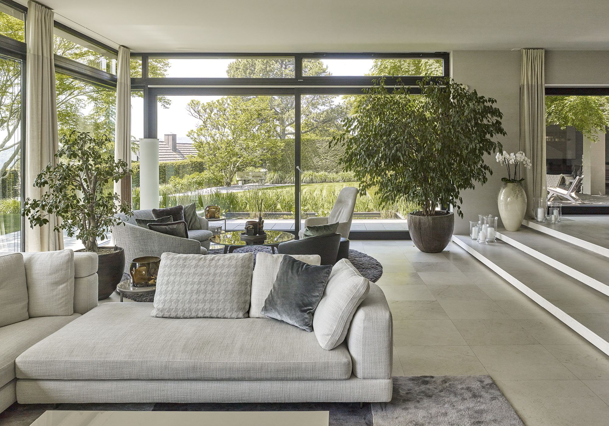 Sofa by the large glass front facing the garden – Single-family house in Uitikon