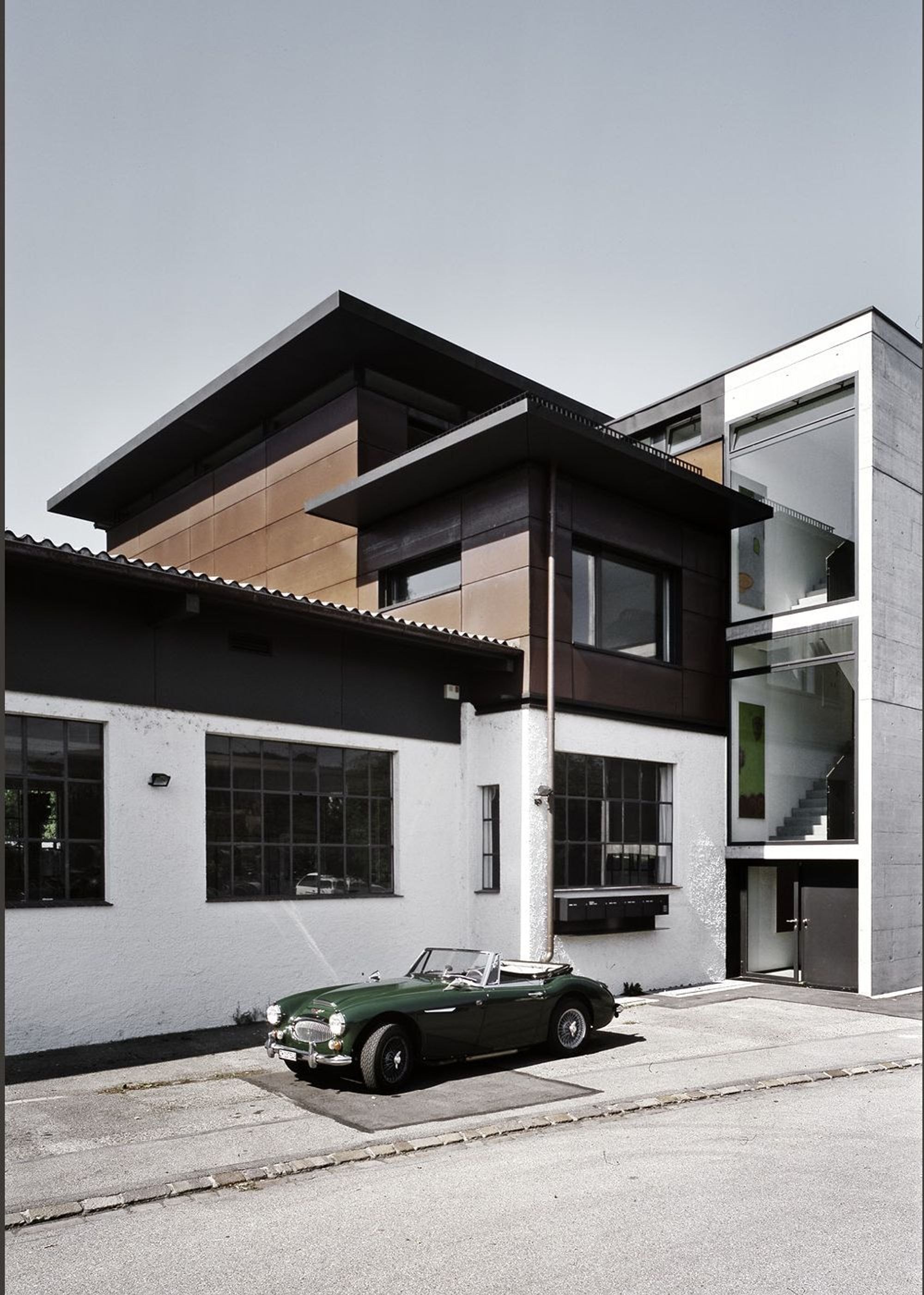 Added storey with timber facade and vintage car – Single-family house in Dietikon