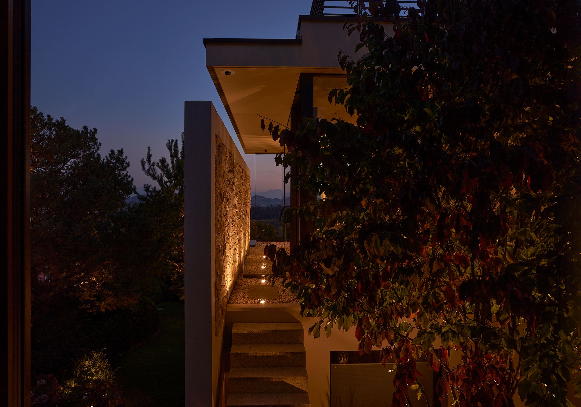 Side facade with natural stone wall and outdoor stairs – Single-family house in Uitikon
