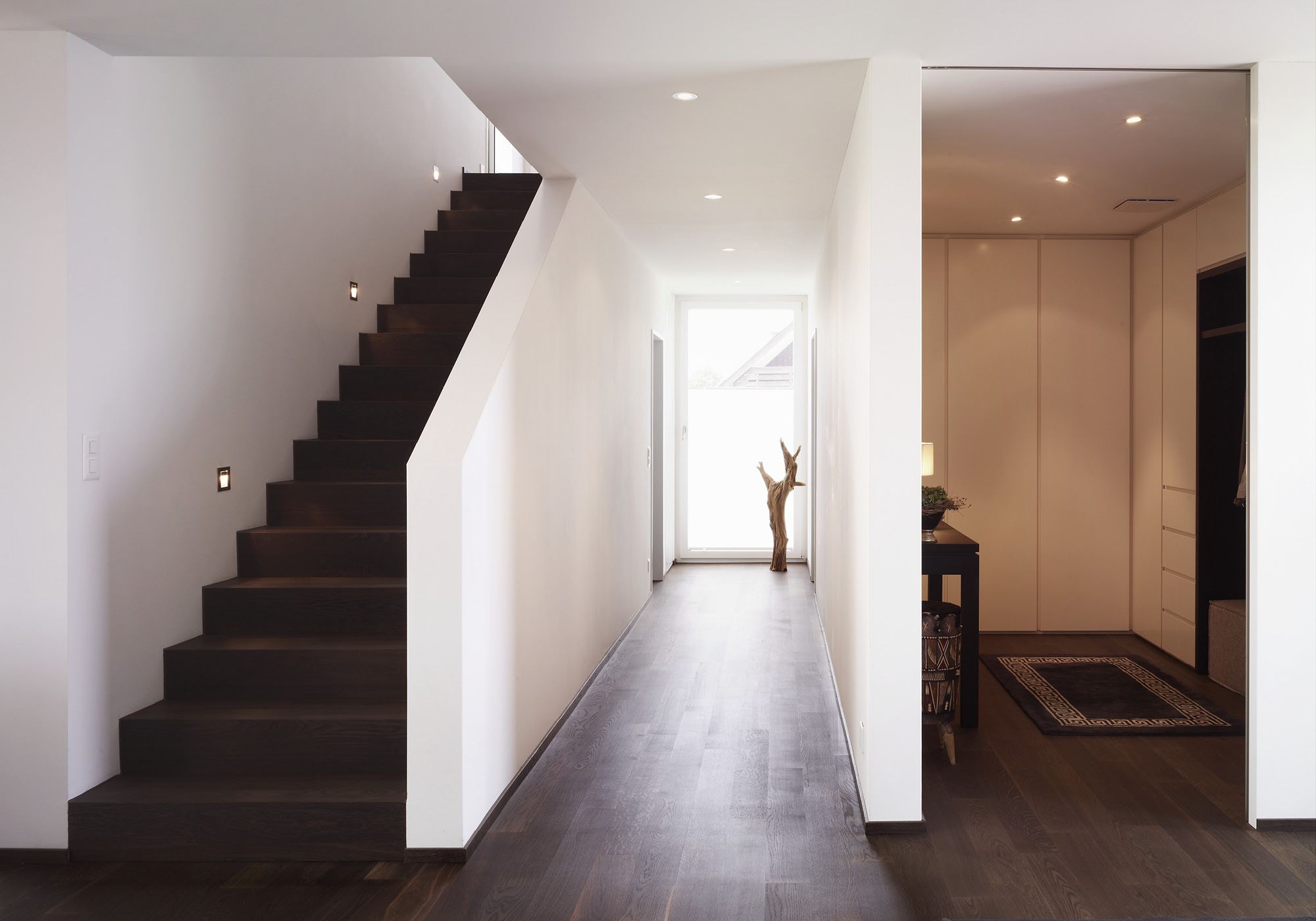 Dark staircase in the white hallway – Single-family house in Russikon