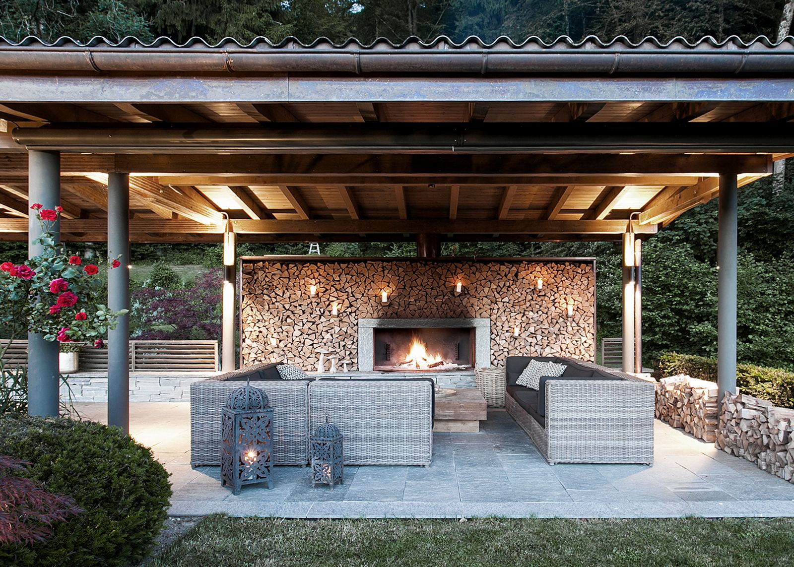 Outdoor fireplace under the timber roof with lounge