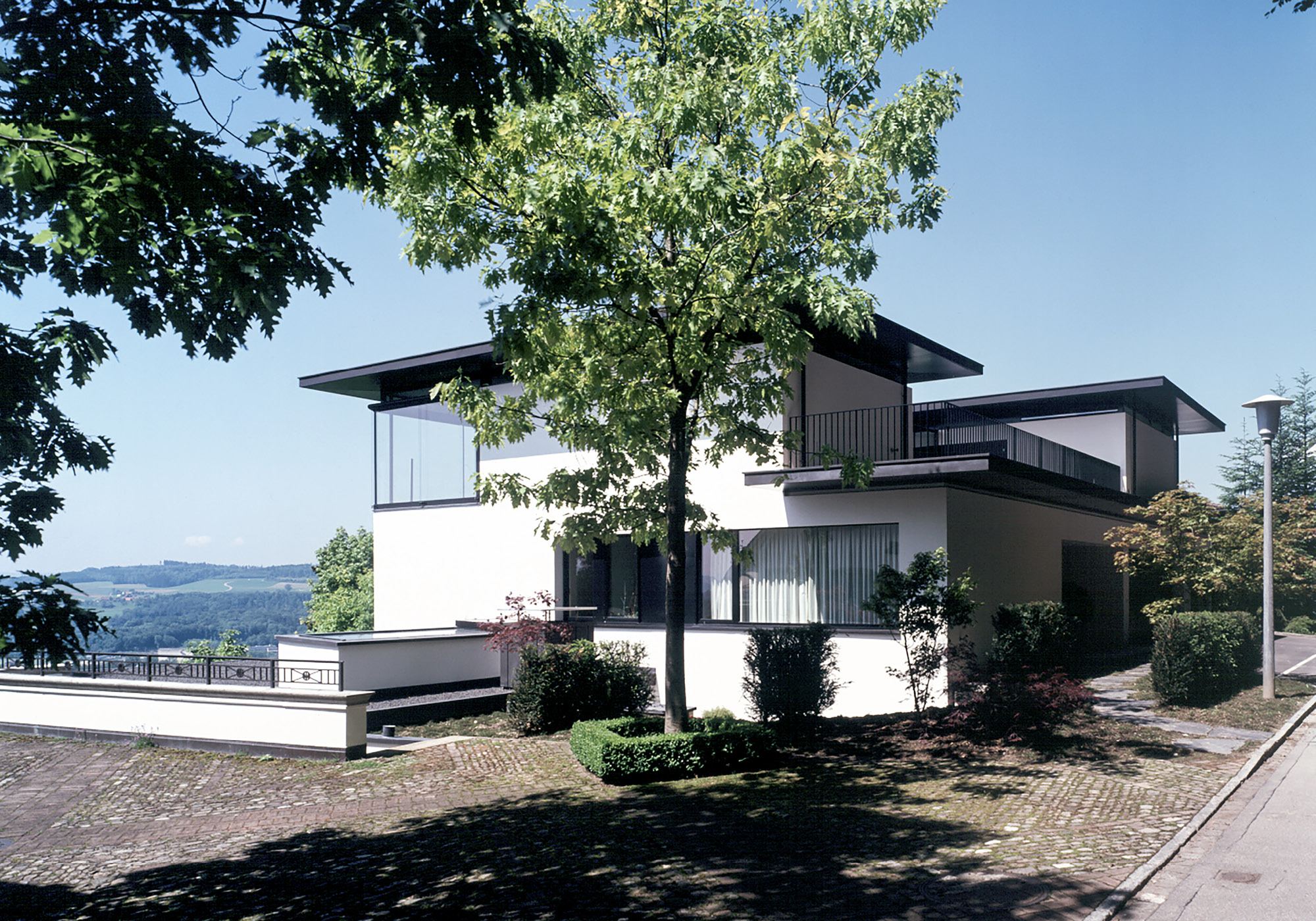 Stepped house with tree by the street – Single-family house in Uitikon
