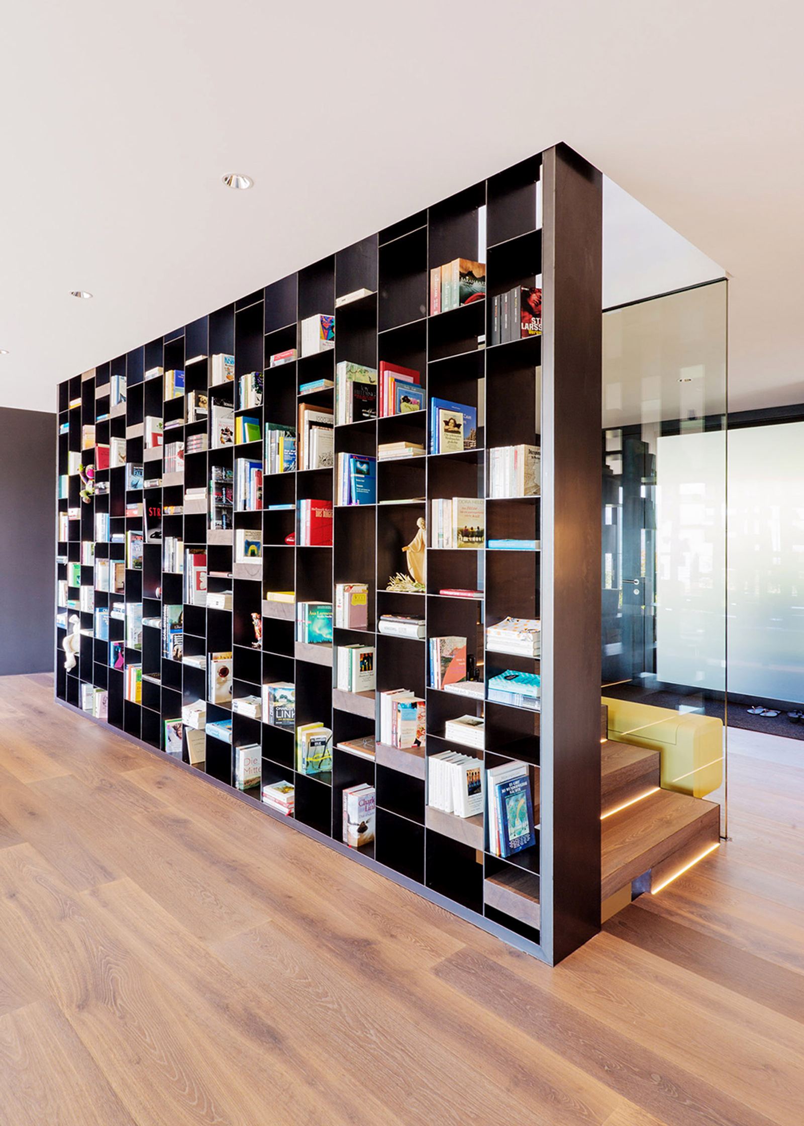 Bookshelf as a room divider beside the staircase
