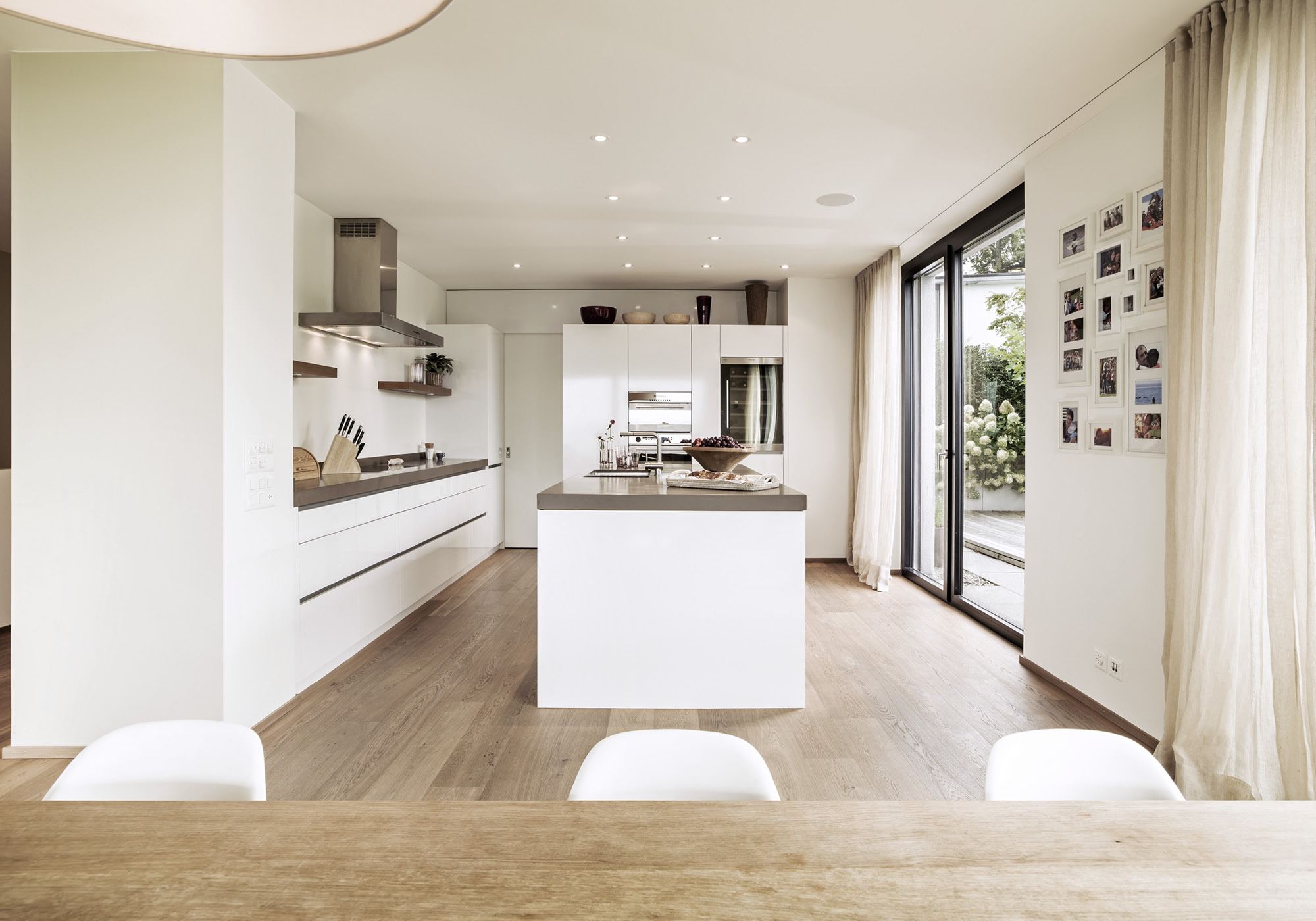 Open kitchen with island and photo wall – Single-family house in Uitikon