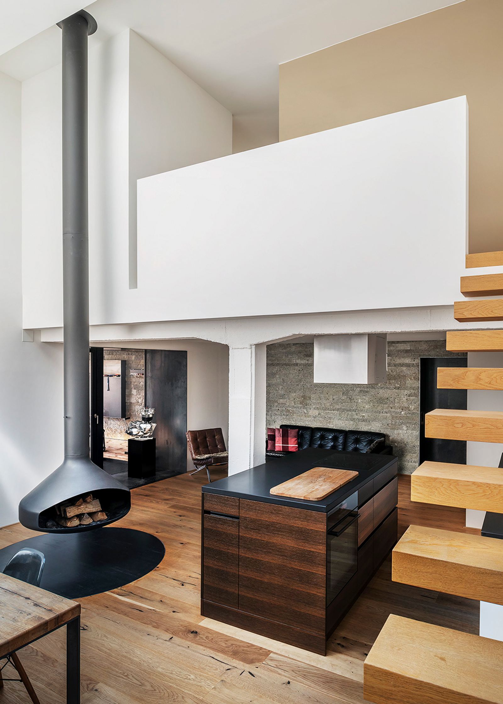 Suspended fireplace beside the timber staircase