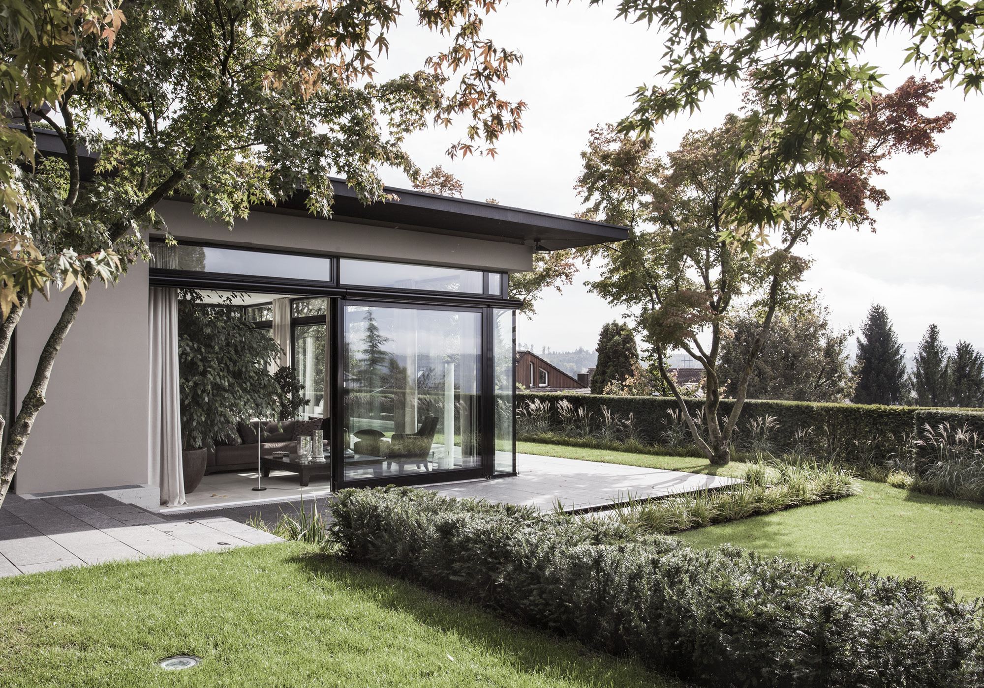 Glass corner with lawn and hedges – Single-family house in Uitikon