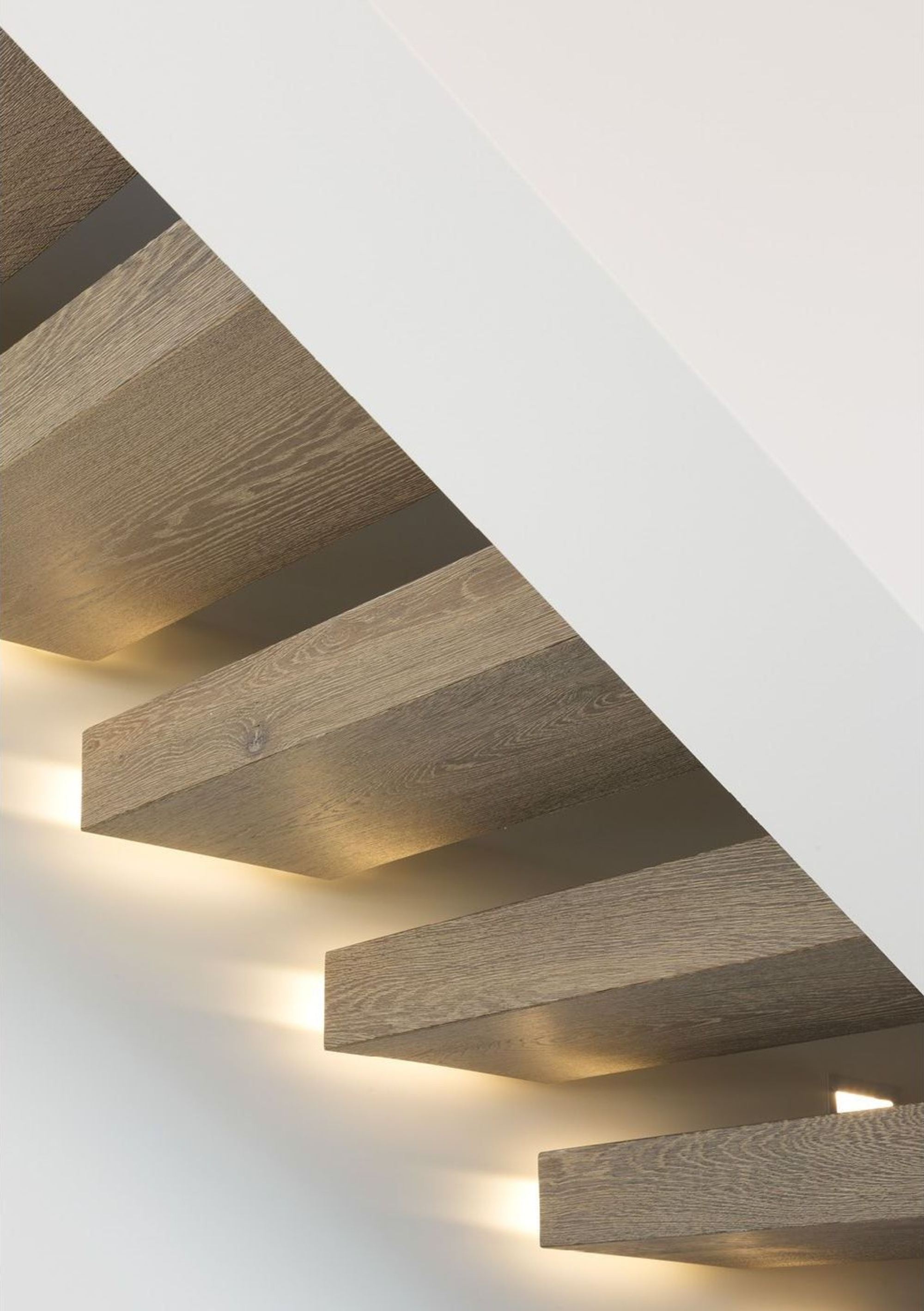 Illuminated timber treads of the cantilevered stair – Single-family house in Wollerau