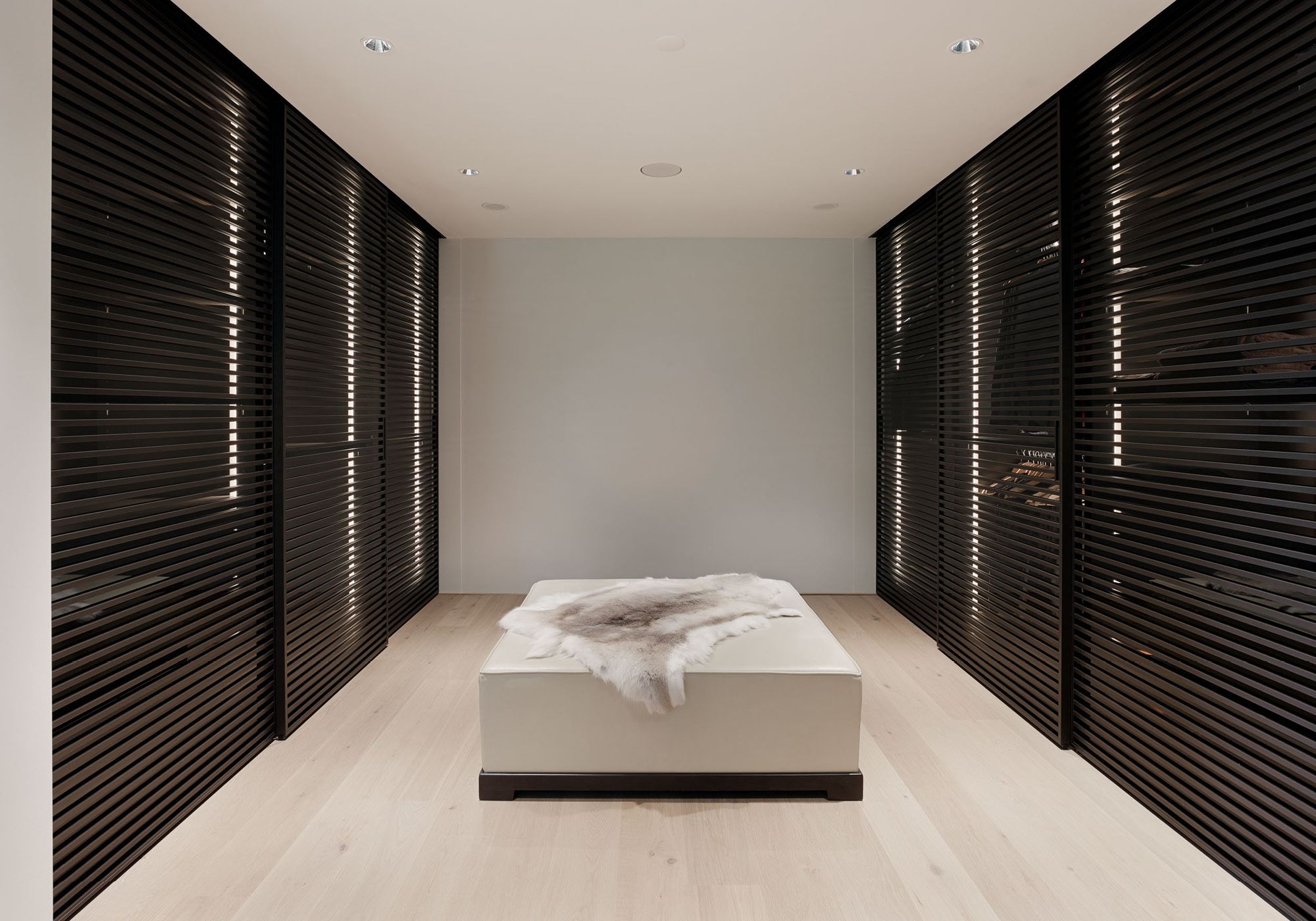 Dressing room with slatted wardrobes and upholstered bench – Single-family house in Uitikon